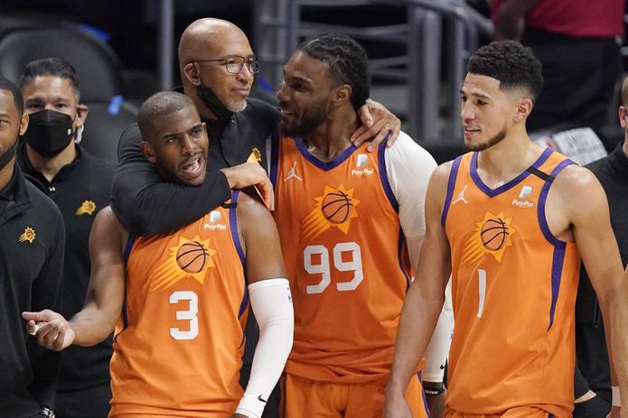 El dirigente de los Suns de Phoenix, Monty Williams, abraza a Chris Paul (3), Jae Crowder (99) y Devin Booker durante los segundos finales del partido del miércoles en Los Ángeles. Los Suns eliminaron a los Clippers y pasaron a la Final de la NBA.
