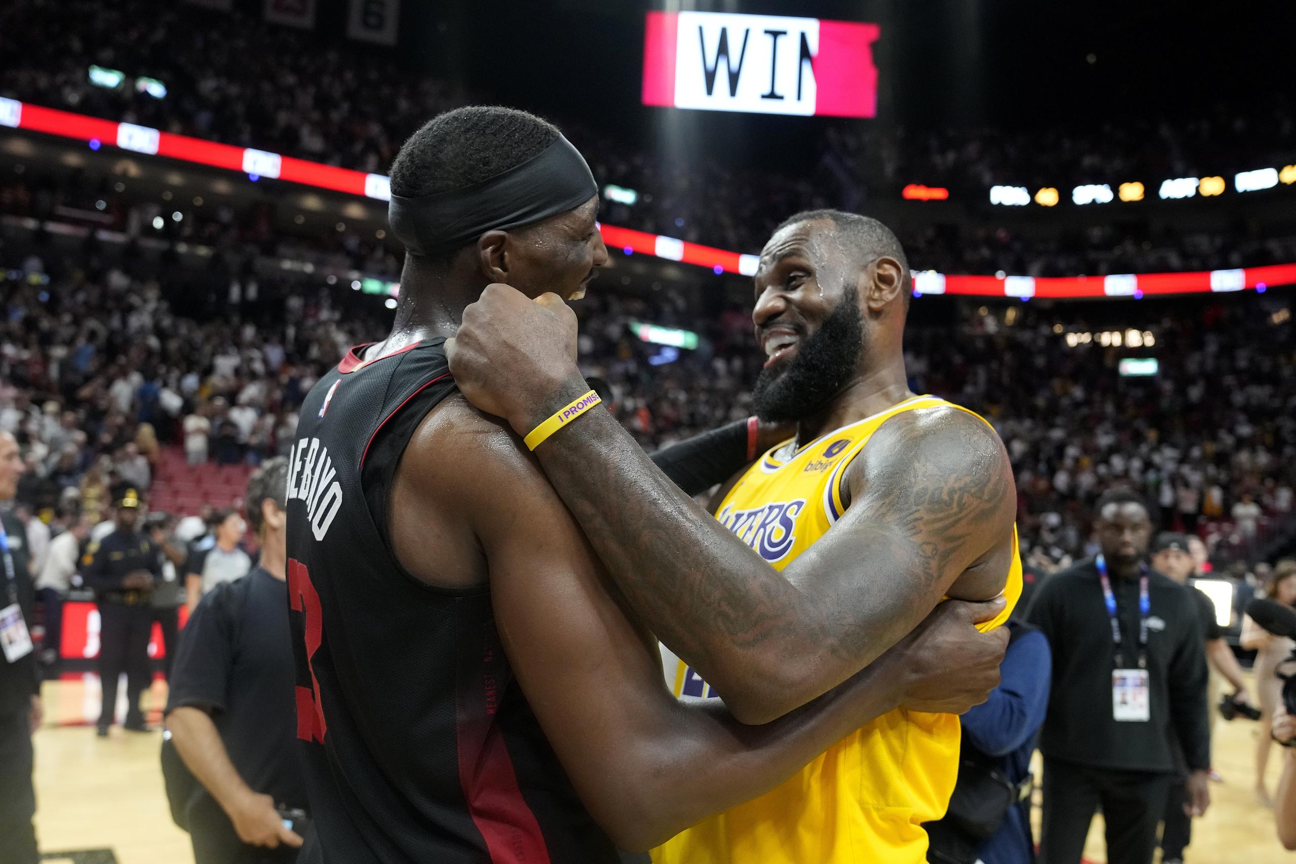 Bam Adebayo, izquierda, del Heat de Miami, y LeBron James, derecha, de los Lakers de Los Ángeles, se encuentran en la duela después del partido de baloncesto de la NBA, el lunes 6 de noviembre de 2023, en Miami. (AP Foto/Lynne Sladky)