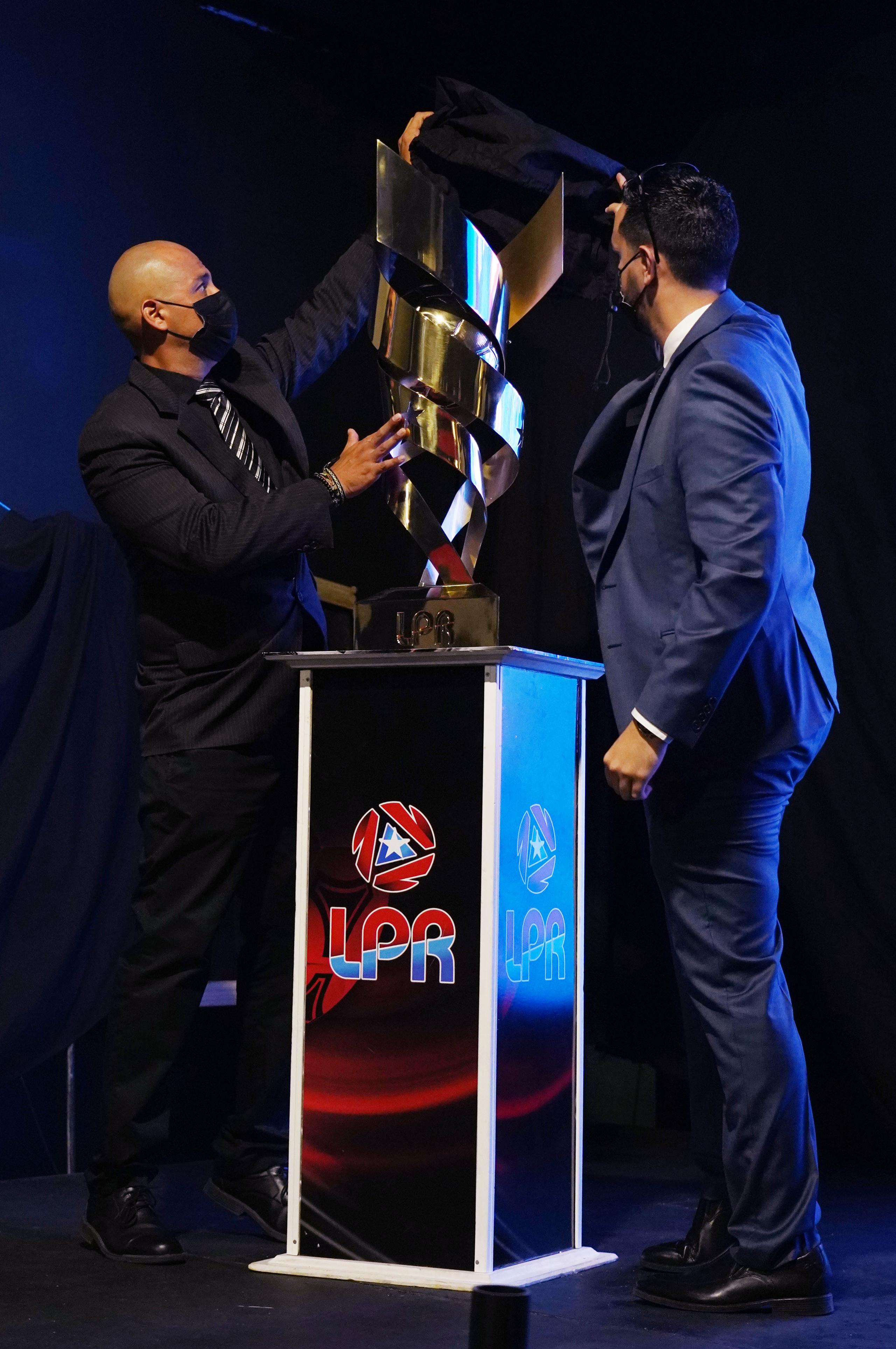 Iván E. Rivera, presidente de la FPF, devela el trofeo del campeonato.
