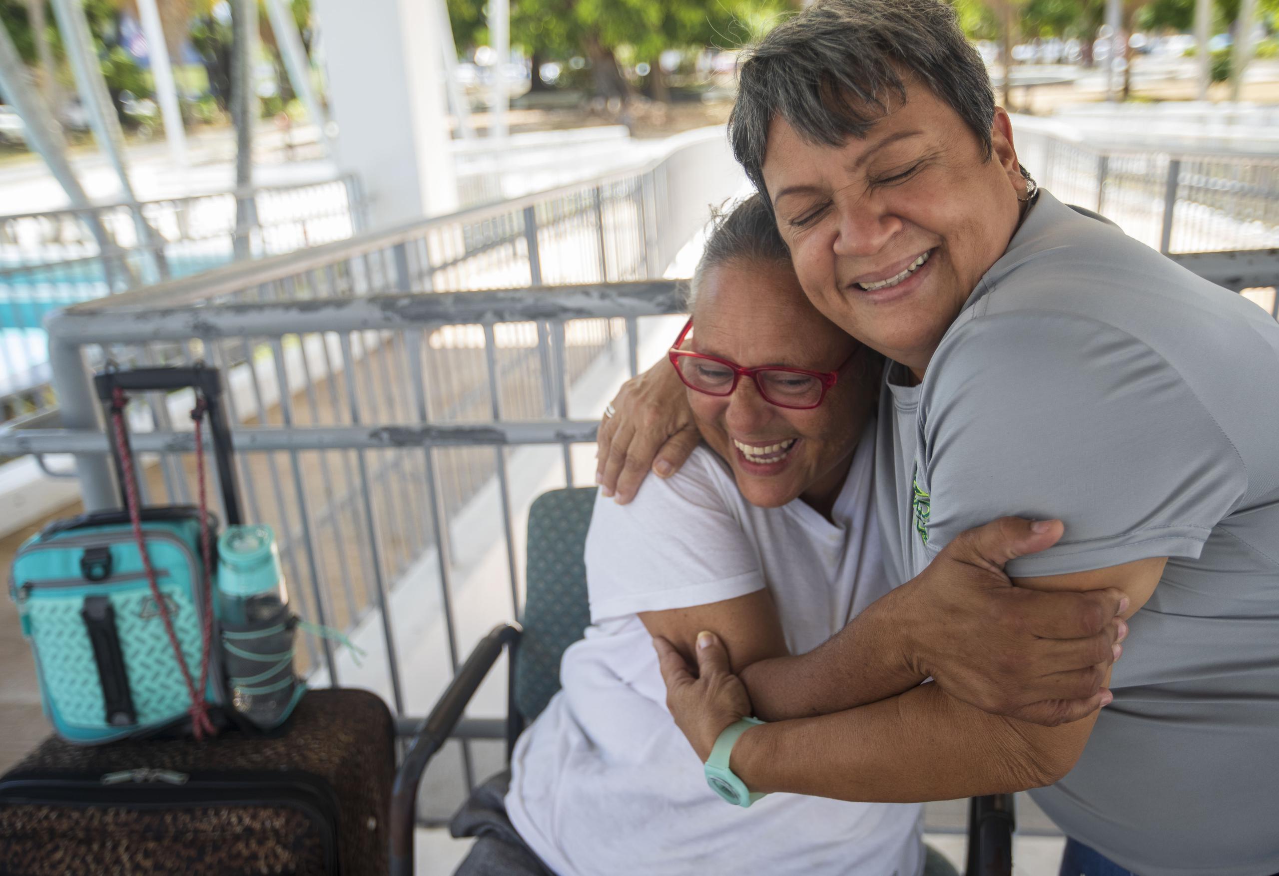 Juanita Reyes Guadalupe (sentada) se abraza con Carmen Romero Dones, quien vivió hace años en la calle y ahora asiste a mujeres que están sin hogar. Gracias al apoyo de Carmen, Juanita logró recientemente estabilizar su situación en una vivienda permanente.