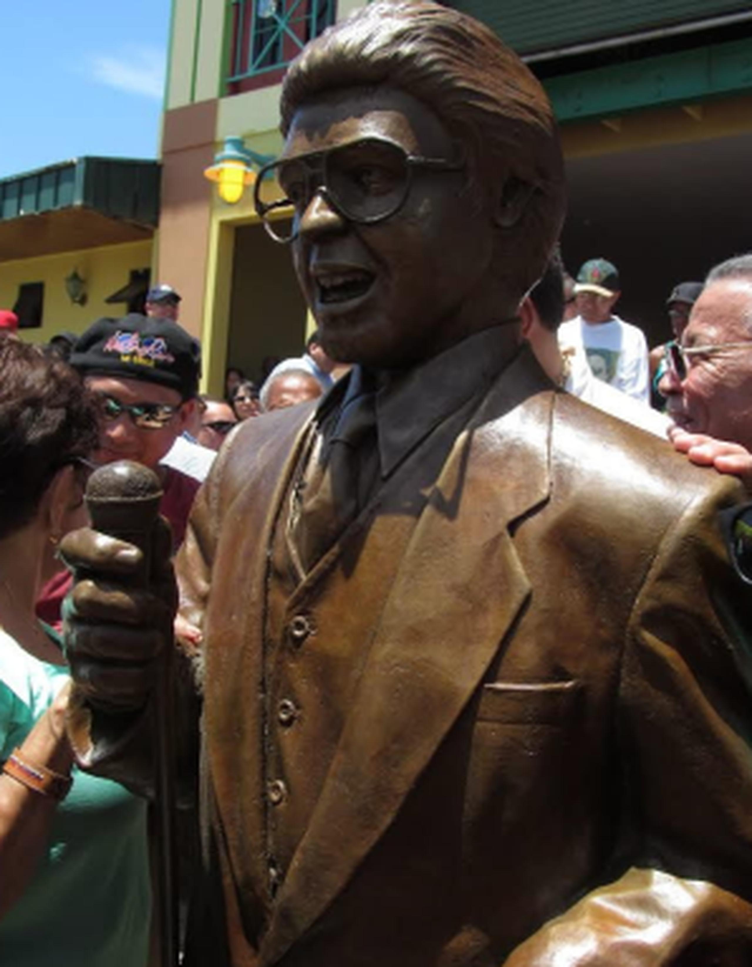 Aficionados posan junto a la estatua del cantante puertorriqueño Héctor Lavoe en el complejo recreativo puertorriqueño La Guancha, en Ponce. (EFE)
