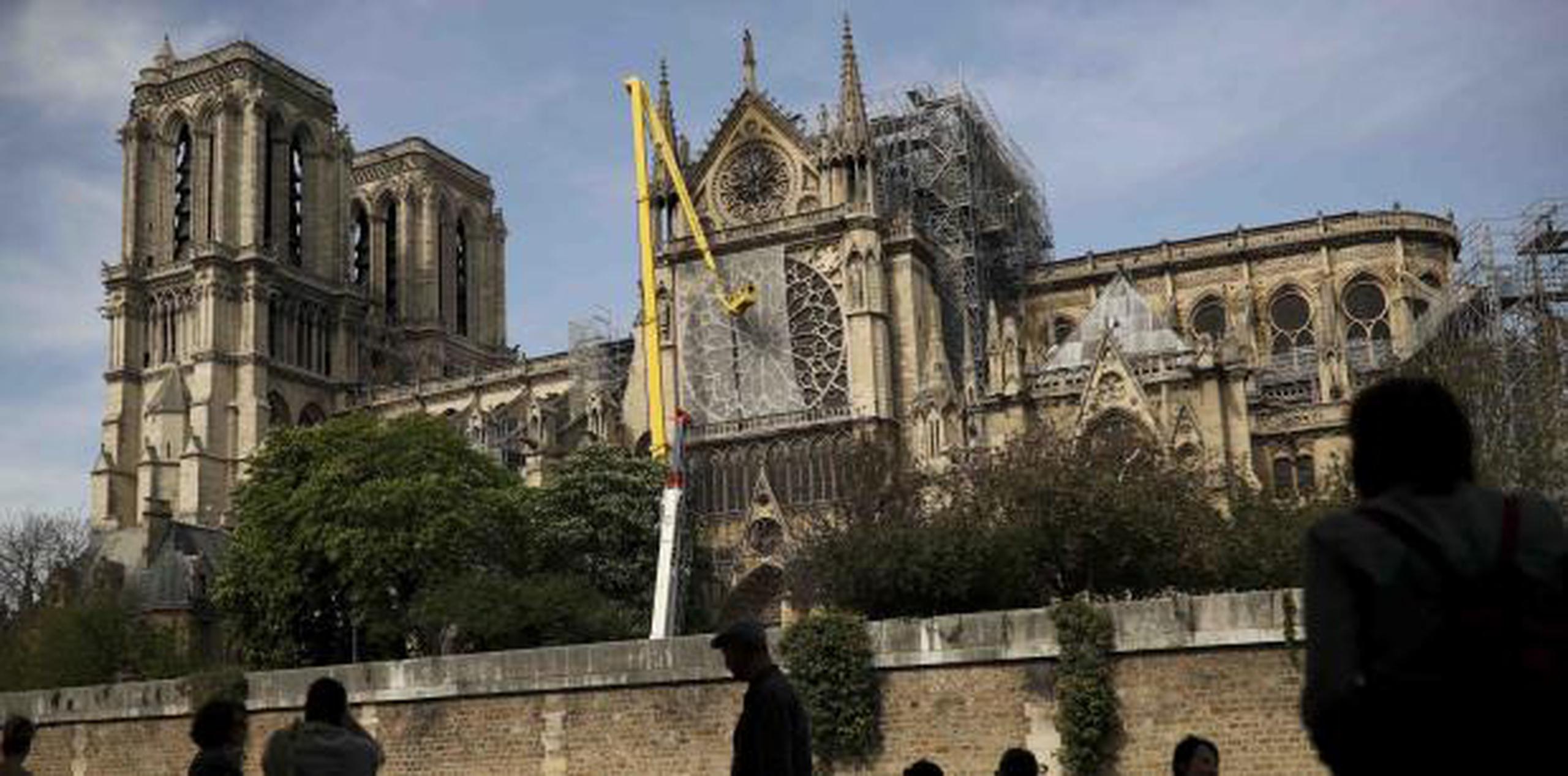 Trabajadores arreglaron una red para cubrir una de las icónicas vidrieras de la catedral de Notre Dame el pasado domingo. (AP / Francisco Seco)