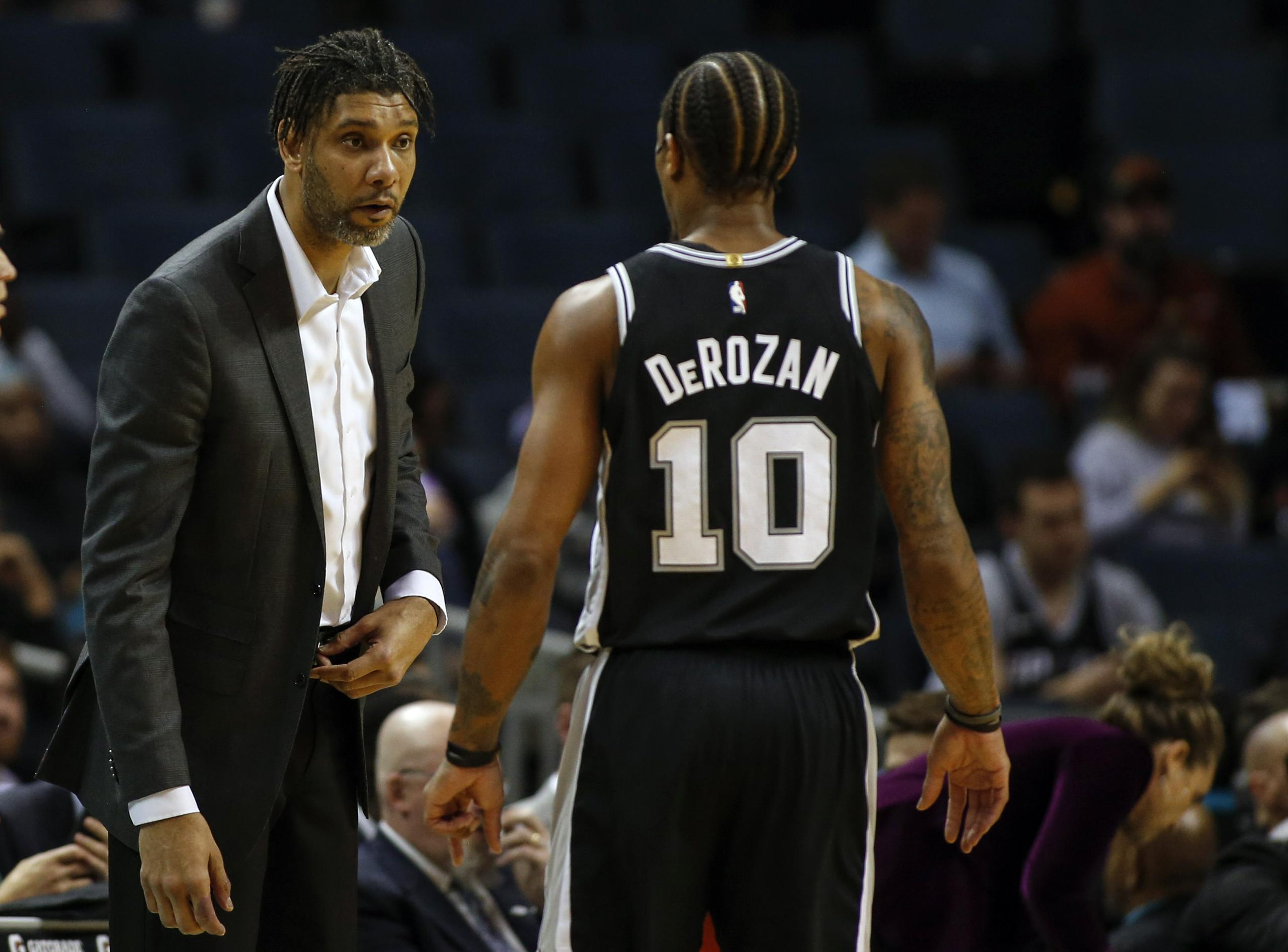 Tim Duncan, entrenador en funciones de los Spurs de San Antonio, habla con el alero DeMar DeRozan, durante el encuentro ante los Hornets de Charlotte.