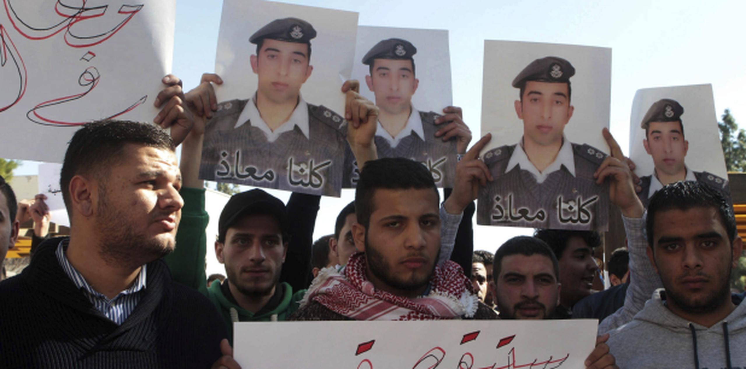 Varios estudiantes muestran fotografías del piloto Muaz Kasasbeh, quien fue asesinado por el grupo yihadista Estado Islámico. (Archivo)