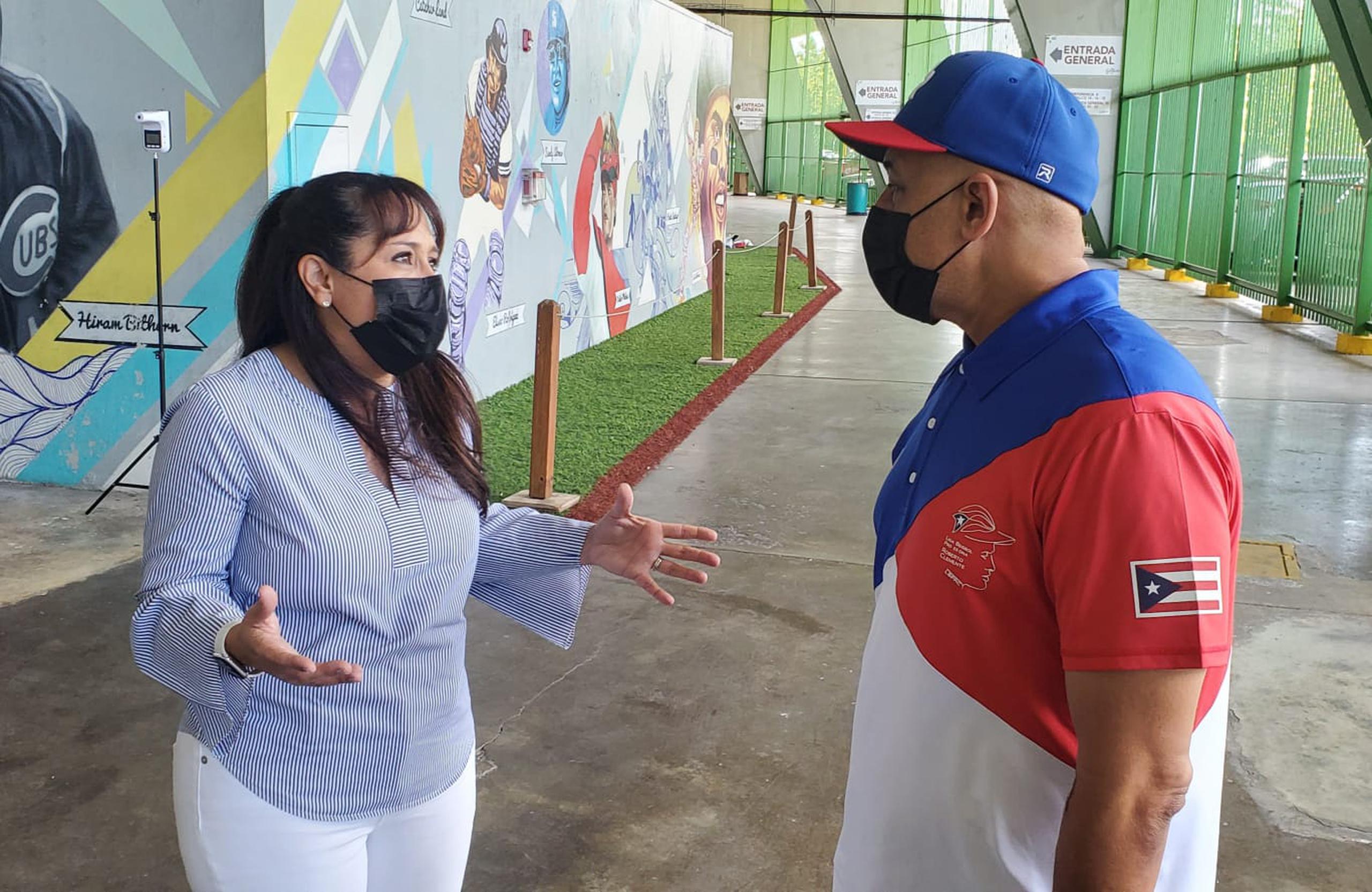 Grace Santana, de WinIn Sports Books, conversa con Carlos Berroa, director del torneo de la Liga de Béisbol Profesional, después de completado el acuerdo.