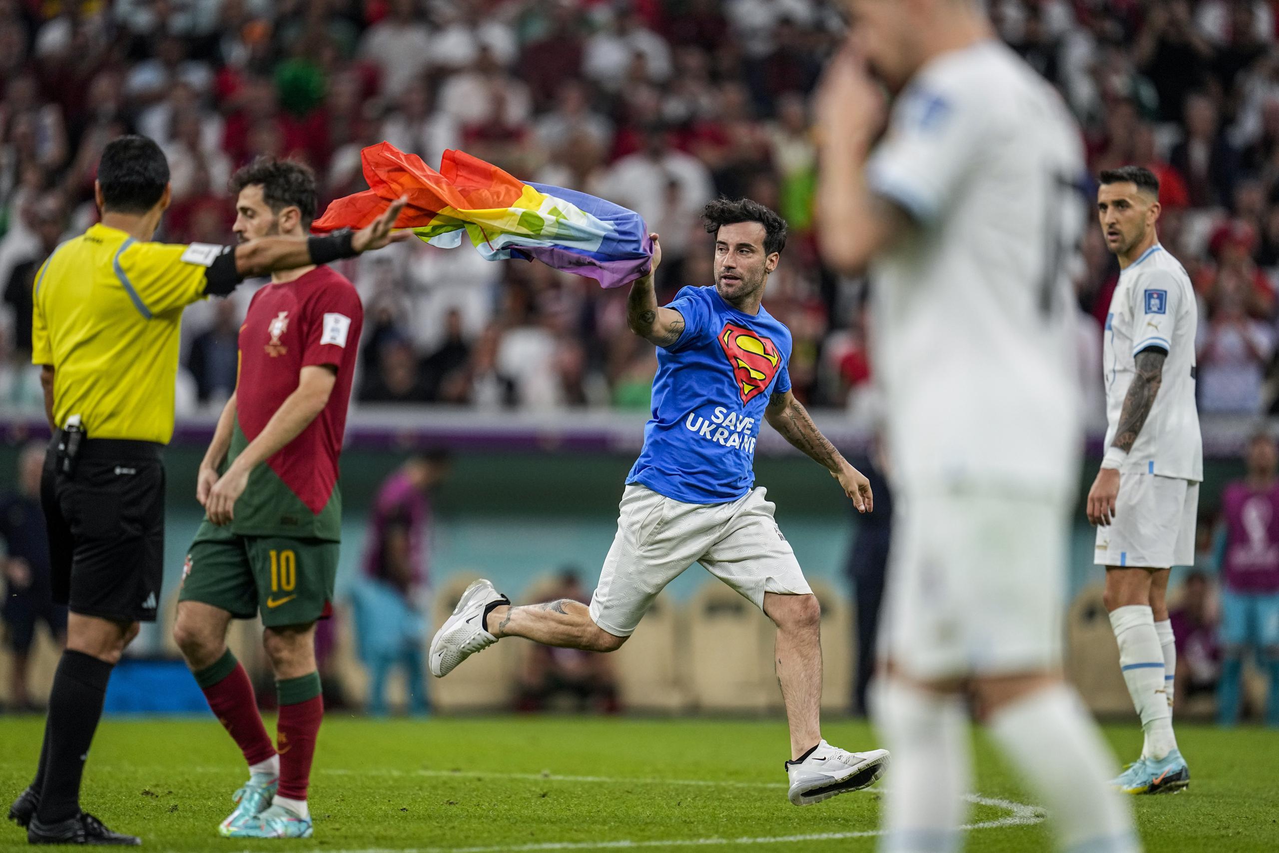 Un aficionado irrumpió en la cancha con la bandera arcoíris durante el partido del Grupo H entre Portugal y Uruguay, el lunes 28 de noviembre de 2022, en Lusail, Qatar.