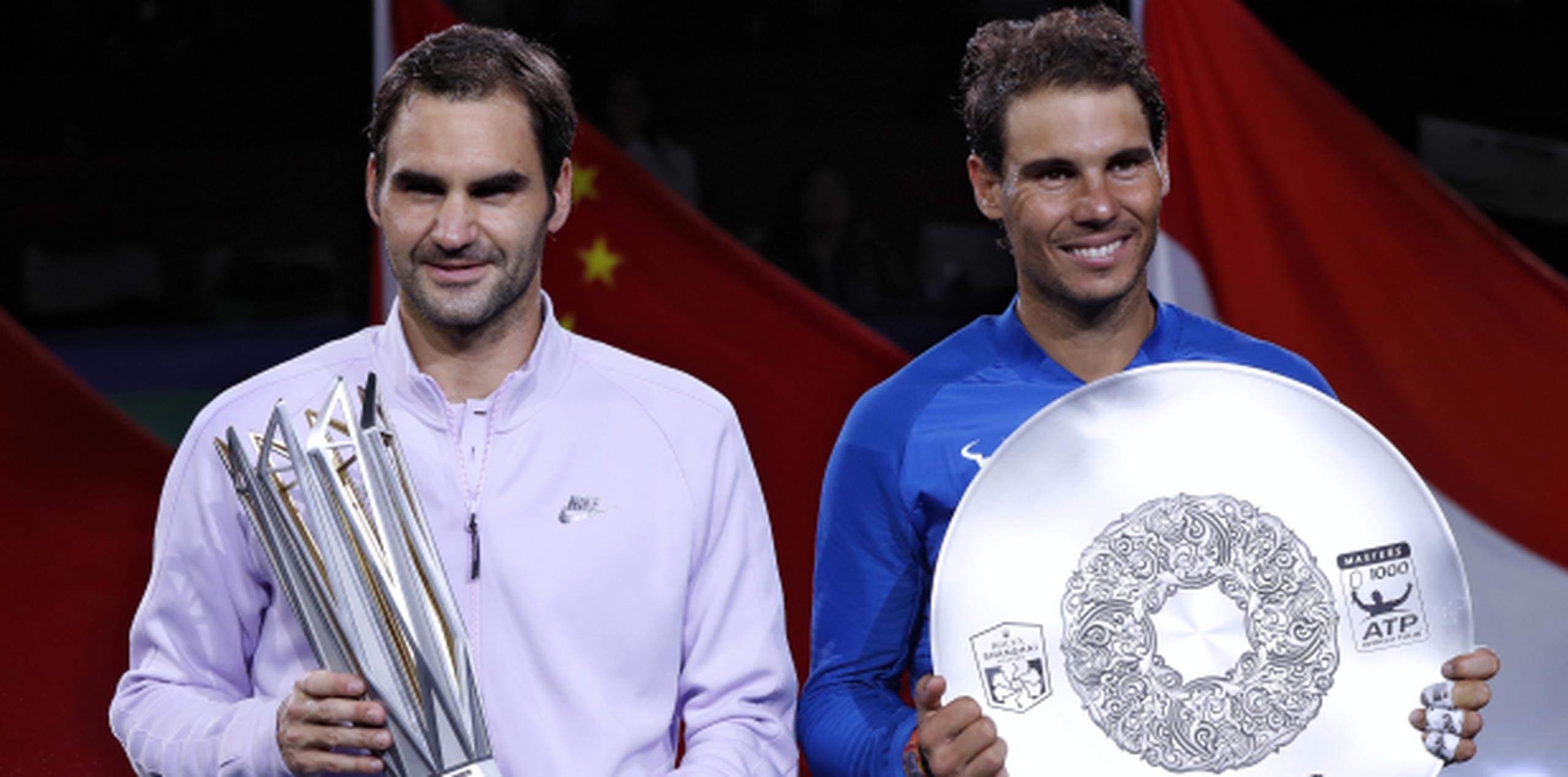 El Masters de Shanghai es el 94to título en la carrera de Federer, aquí de blanco junto a Nadal, lo que lo coloca en un empate en el segundo lugar general en la lista de la era de los Abiertos.  (AP)