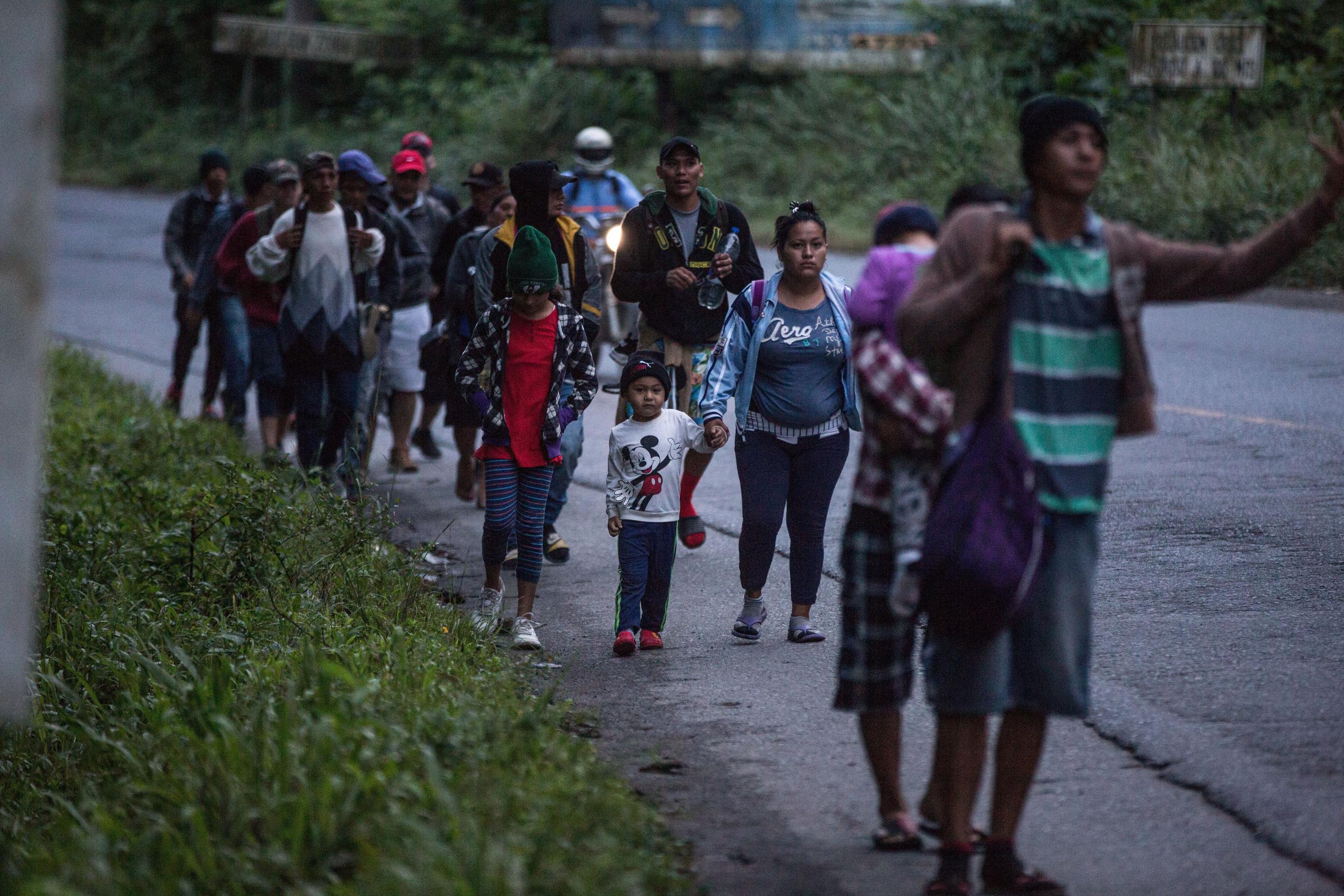 Migrantes hondureños continúan hoy su camino en caravana hacia Estados Unidos mientras caminan por una carretera de El Cinchado (Guatemala).