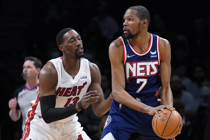 El delantero de los Nets de Brooklyn, Kevin Durant (7), se apresta a pasar el balón ante la defensa de Bam Adebayo, del Heat de Miami.