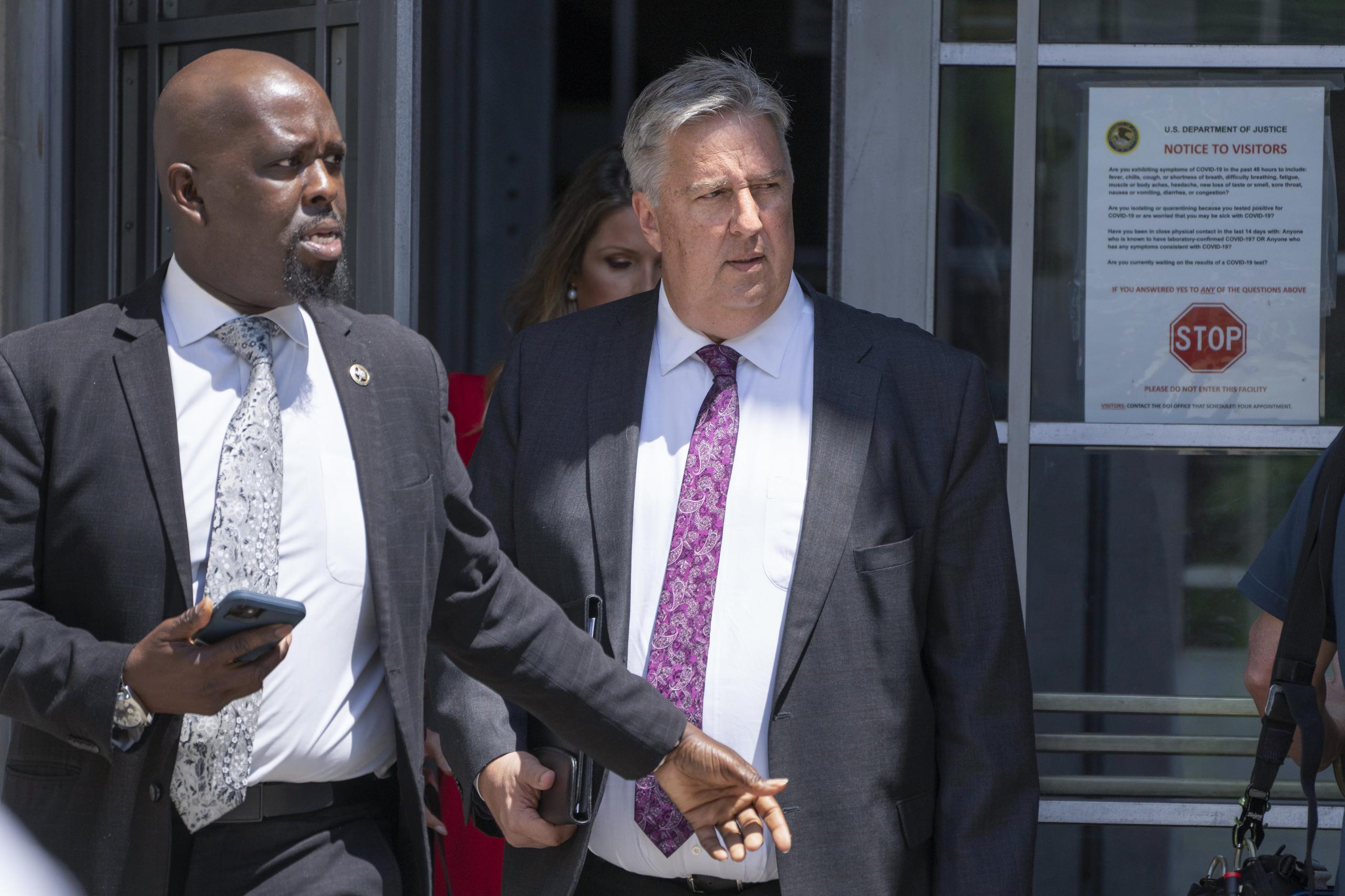El abogado del expresidente Donald Trump, James Trusty (derecha), sale del edificio del Departamento de Justicia de Estados Unidos.