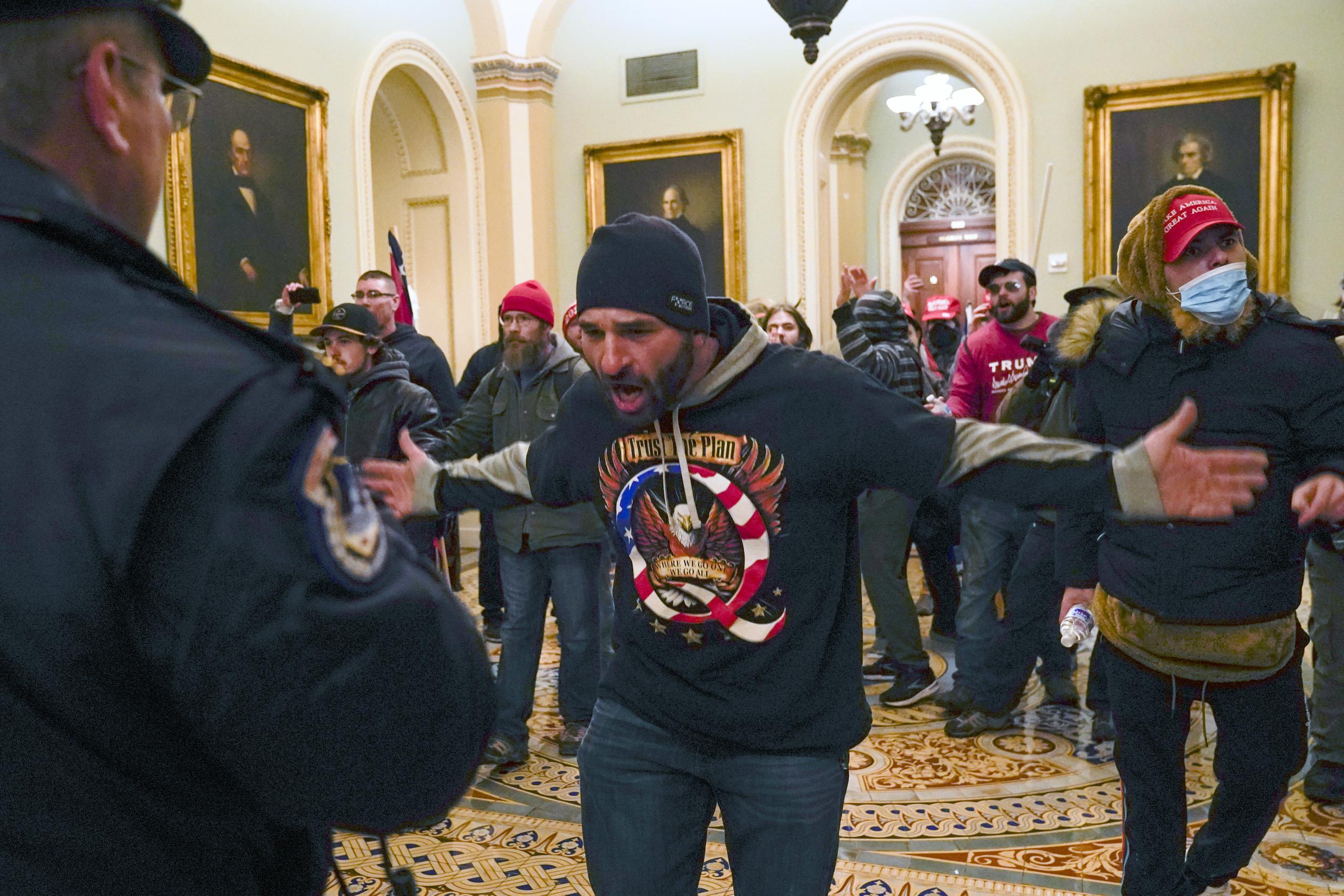 Simpatizantes del presidente Donald Trump se enfrentan a la policía del Capitolio en el pasillo afuera del recinto del Senado, el miércoles 6 de enero de 2021, en Washington.
