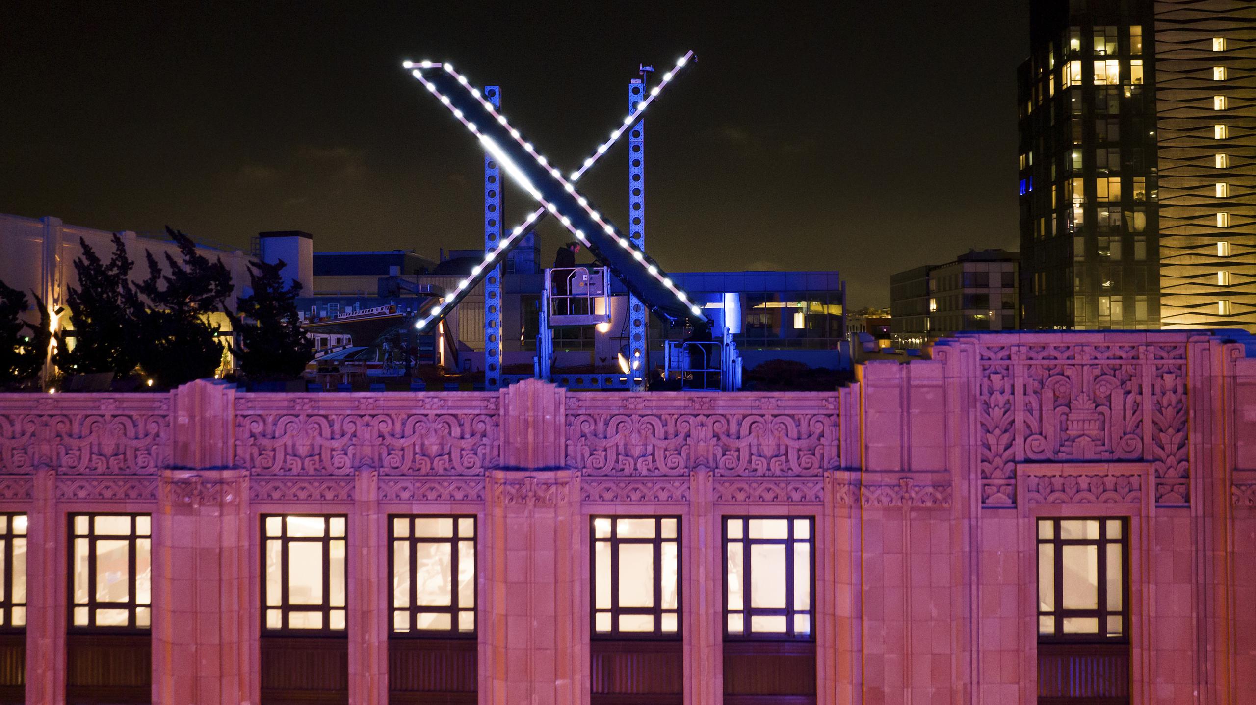Trabajadores instalan una "X" luminosa en el techo de la empresa, antes llamada Twitter, en el centro de San Francisco, 28 de julio de 2023.  Se ha retirado el cartel días después de su instalación. (AP Foto/Noah Berger)