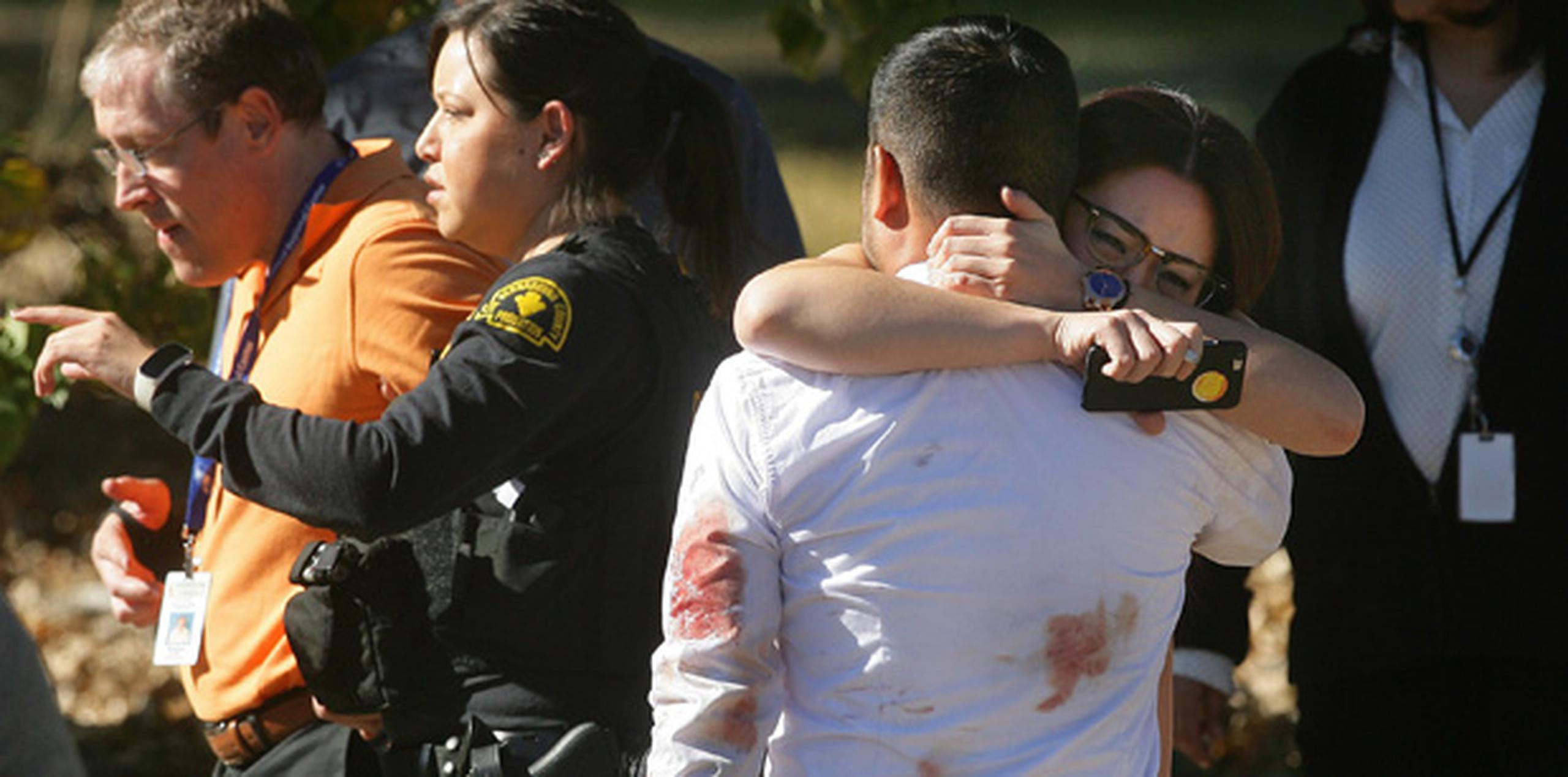 Una pareja se abraza tras un tiroteo en el que murieron varias personas en un centro de servicios sociales en San Bernardino, California. (AP)