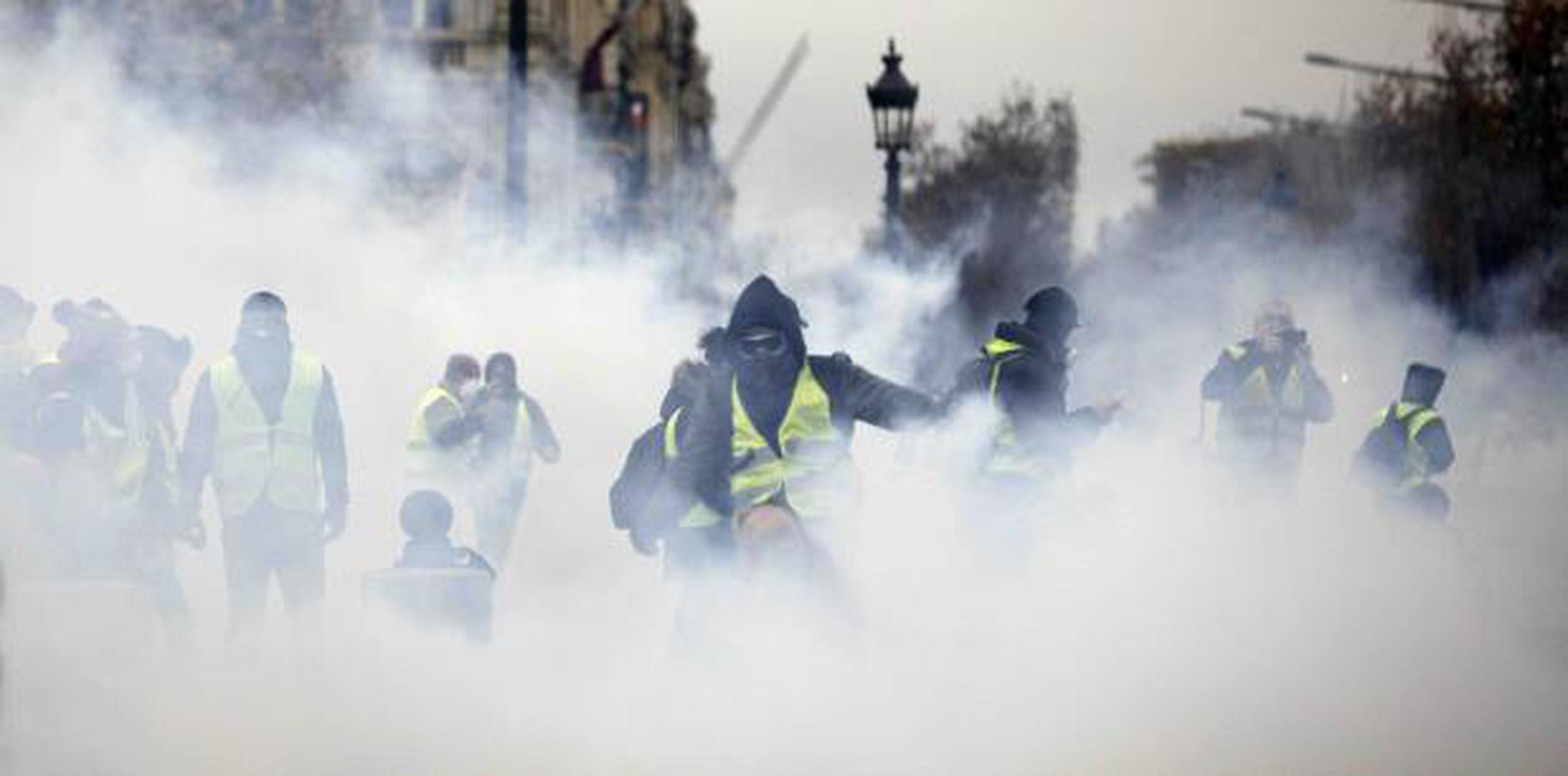 Manifestantes enmascarados protestaron el pasado sábado cerca de la avenida Champs-Elysees en París. (AP / Kamil Zihnioglu)