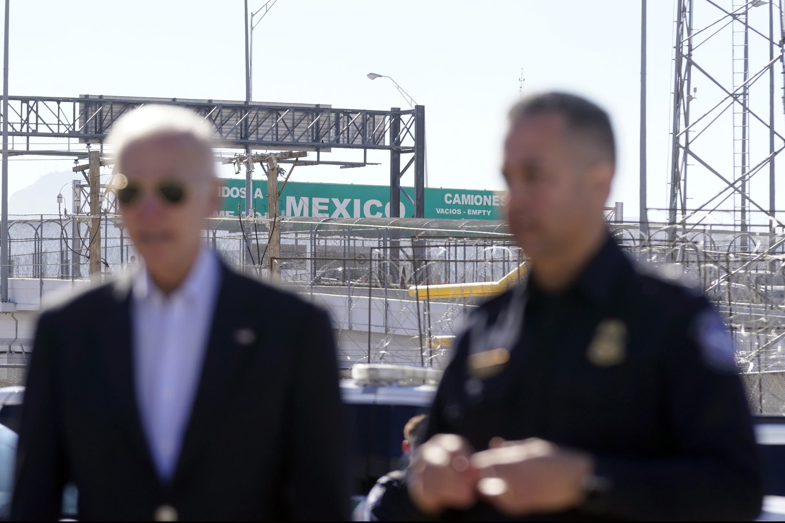 Un letrero grande de "Bienvenidos a México" sobre el Puente de las Américas detrás del presidente estadounidense Joe Biden y un agente de la Oficina de Aduanas y Protección Fronteriza mientras recorren un puerto de entrada en El Paso, Texas, el domingo 8 de enero de 2023. (AP Foto/Andrew Harnik)