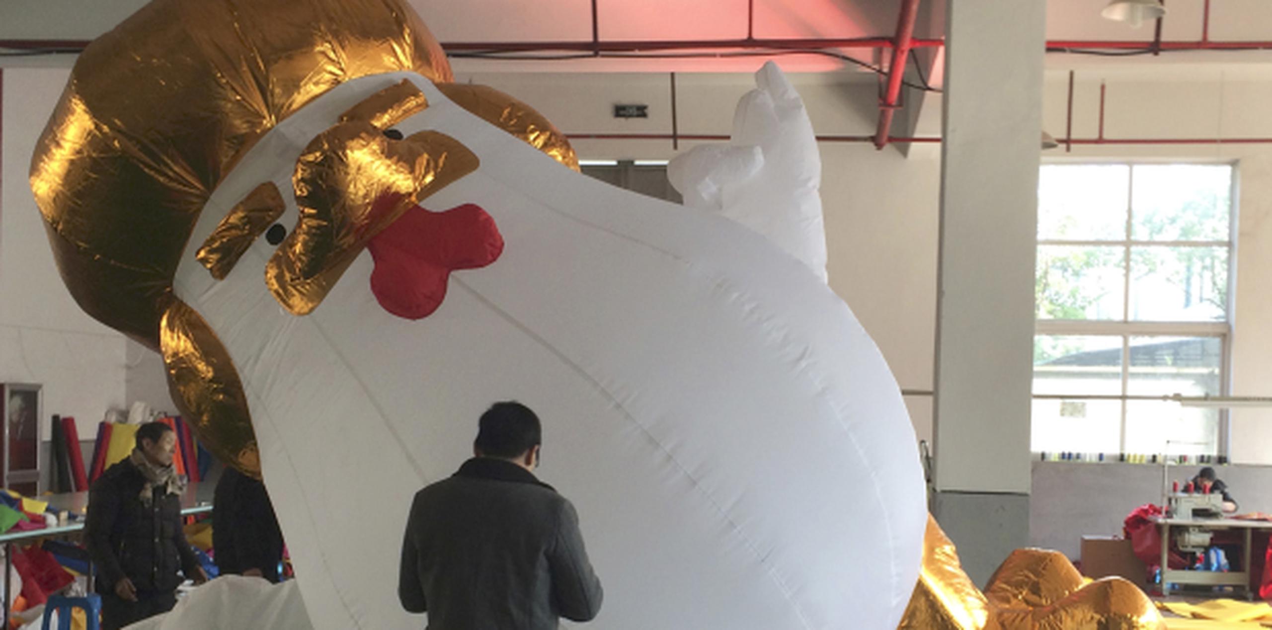 Un grupo de trabajadores en la fábrica de Yifang Inflatables revisa un gallo inflable que refleja semejanzas con el presidente Donald Trump. (AP/Paul Traynor)