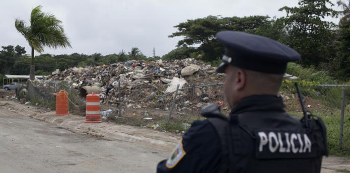 La montaña de basura está cerca de áreas recreativas. En la foto, un oficial custodia la zona para evitar el depósito de escombros. (Para Primera Hora / Alvin J. Báez)