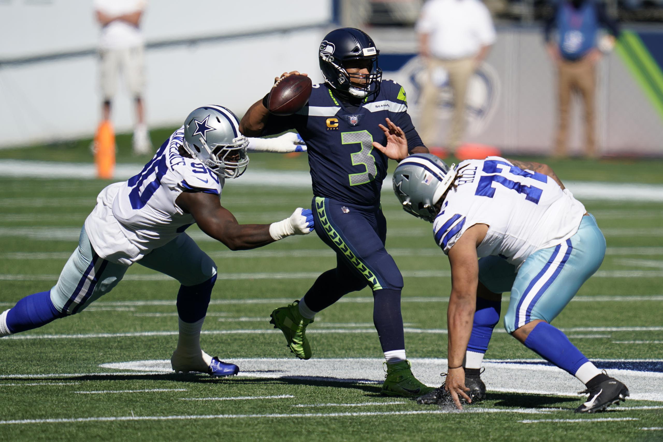 El 'quarterback' de los Seattle Seahawks, Russell Wilson, se apresta a realizar un pase mientras es asediado por la defensa de los Dallas Cowboys.