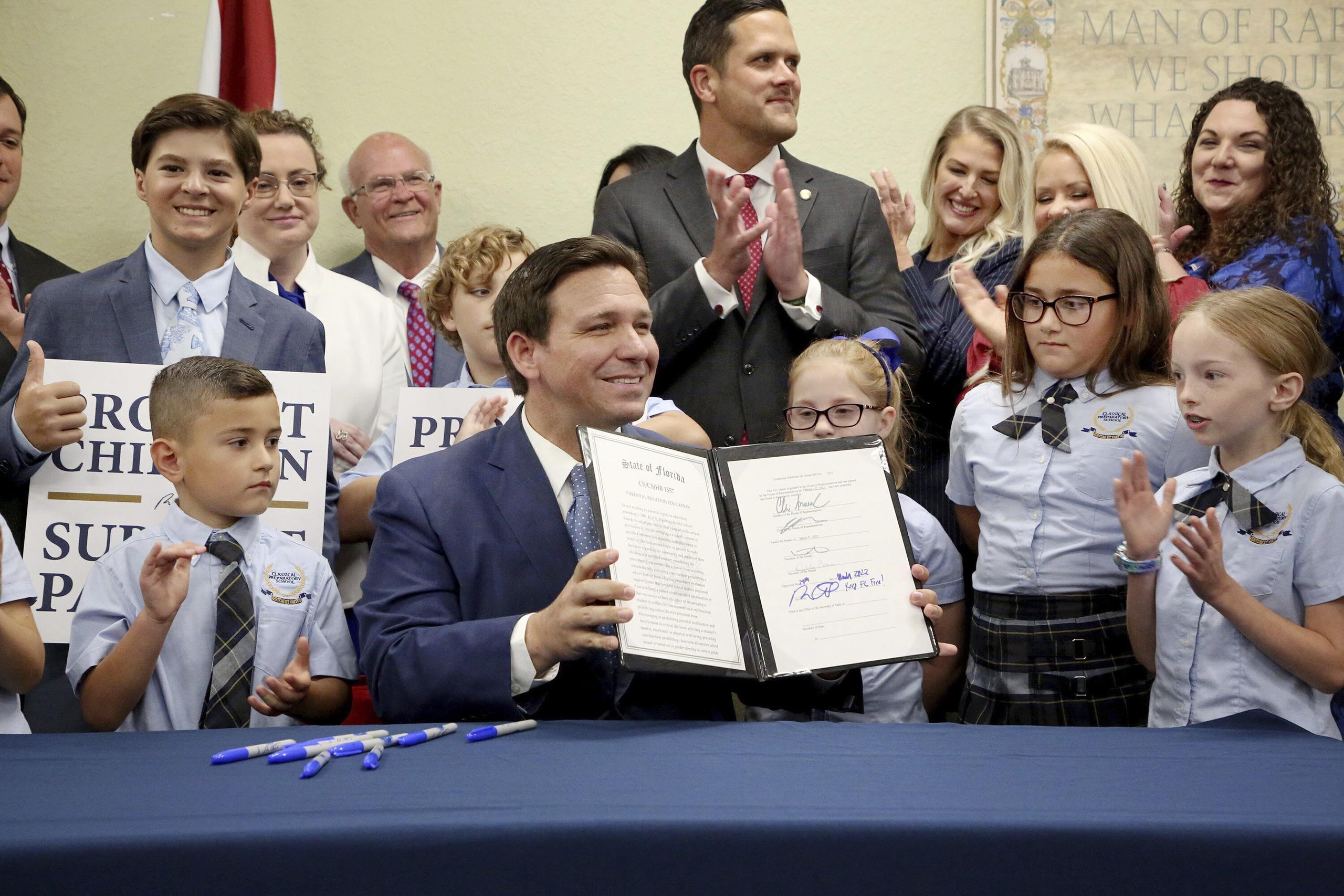 El gobernador de la Florida Ron DeSantis muestra la firma que estampó en una ley sobre los derechos de los padres en el campo de la educación, que sus detractores describen como la ley del "No Digas Gay".  (Douglas R. Clifford/Tampa Bay Times via AP)