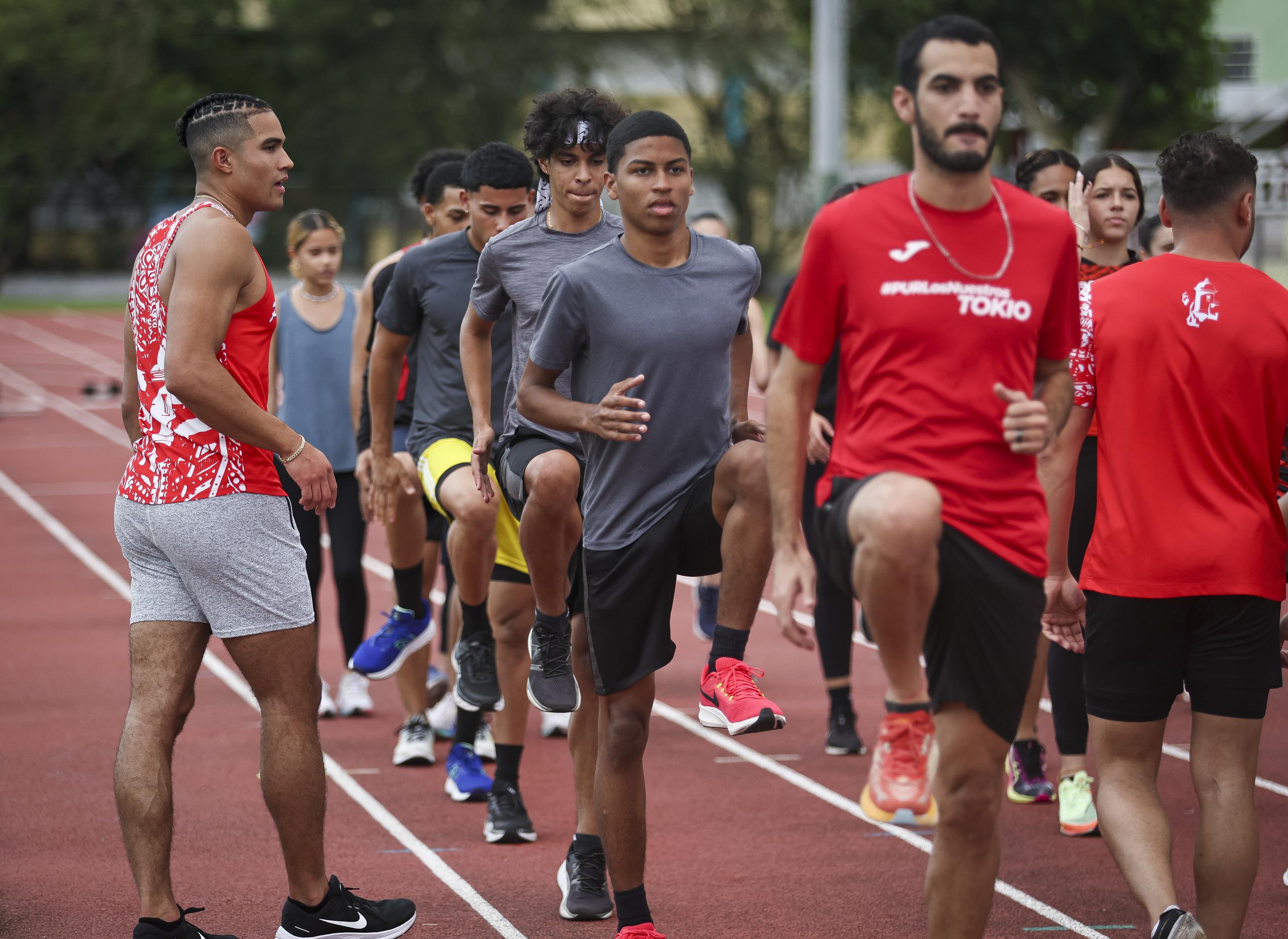 Ayden Owens asiste a un puñado de atletas en la pista atlética Basilio Rodríguez en Carolina.