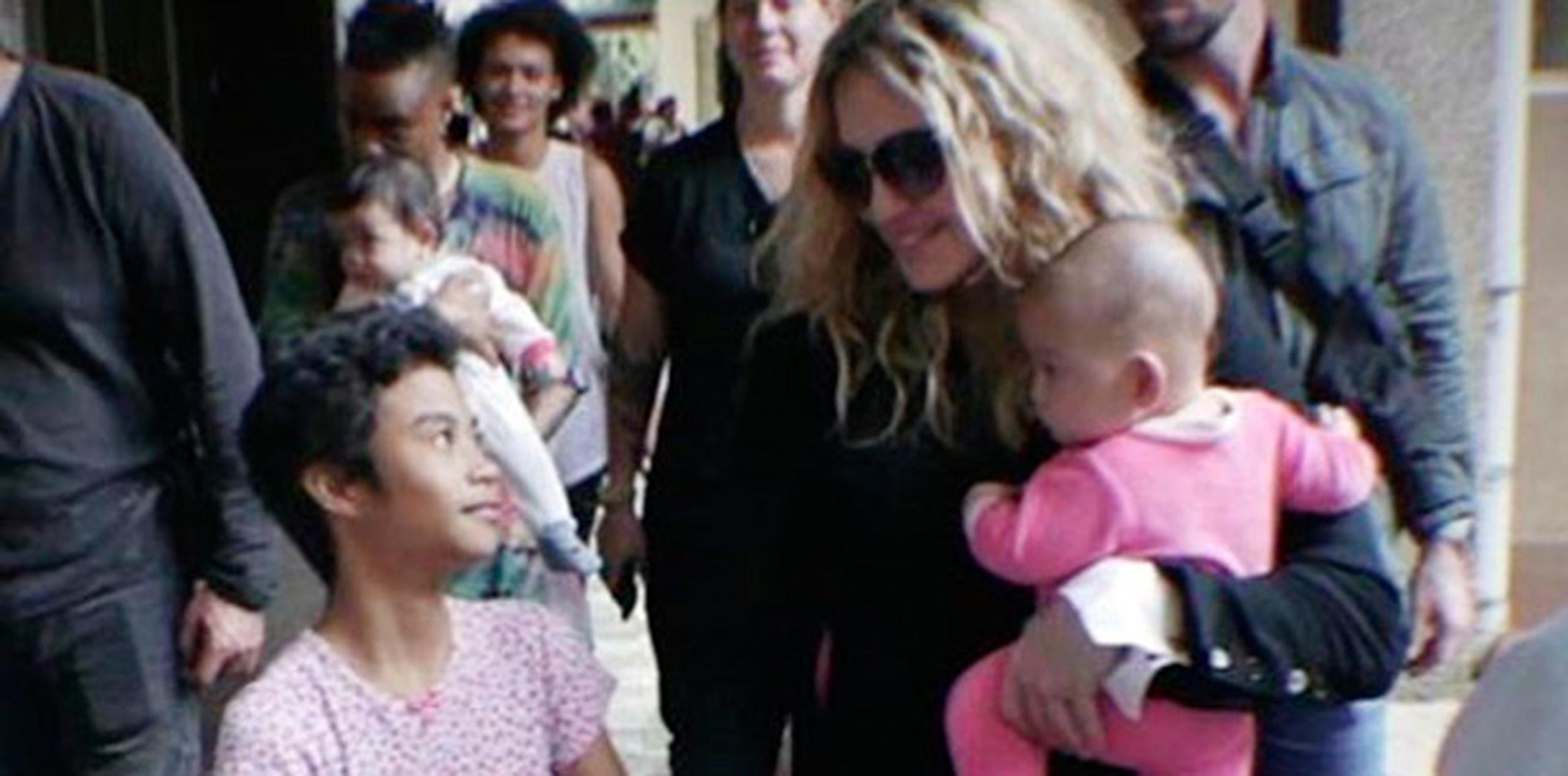 En una de las imágenes publicadas en su cuenta de Instagram, la cantante lleva a una bebé en brazos mientras da la mano a otra niña que ejerció de guía durante su visita del martes al Hospicio de San José.