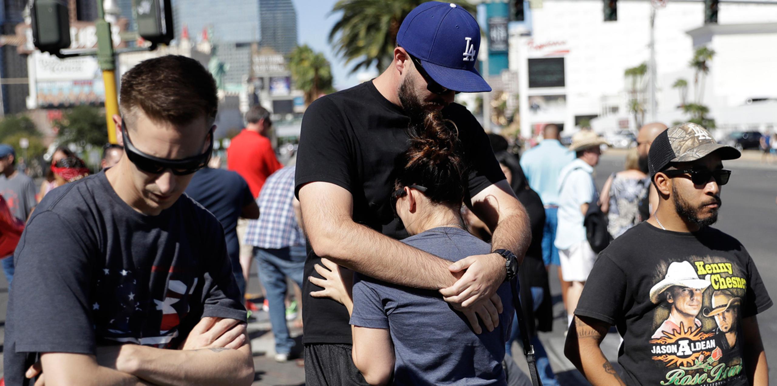 Reed Broschart, en el centro, abraza a su novia Aria James en el Strip de Las Vegas tras el tiroteo masivo. (AP)
