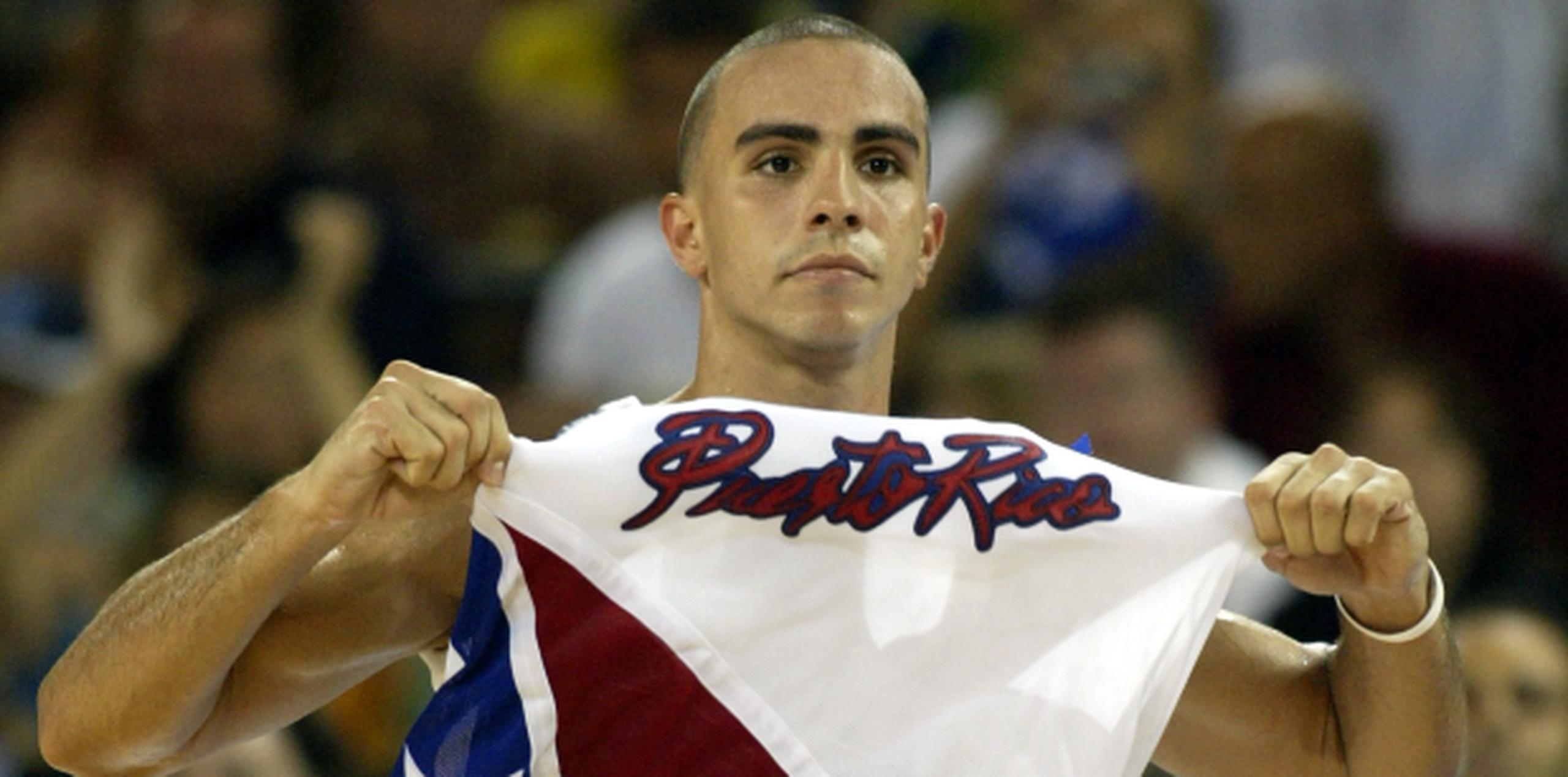 El armador Carlos Arroyo levanta el nombre de Puerto Rico en su franela luego que ayudó al quinteto boricua a derrotar al Dream Team de Estados Unidos en las Olimpiadas de 2004 en Atenas, Grecia. (Archivo)