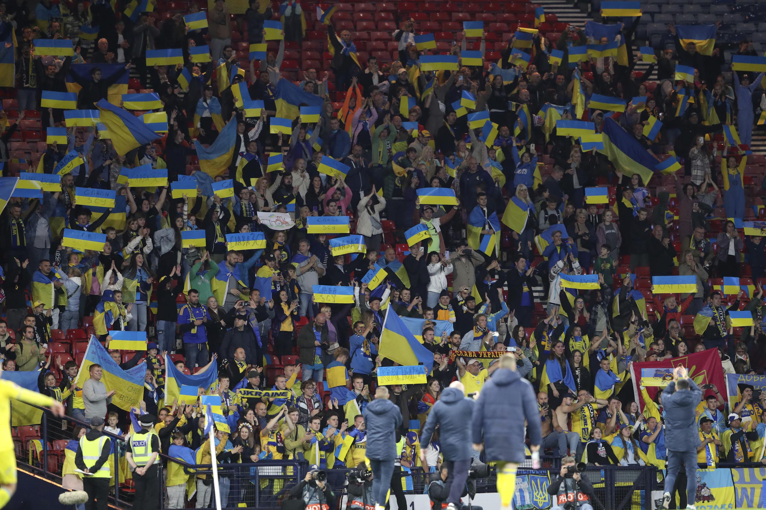 Aficionados de Ucrania sostienen banderas del país al final del partido de la Liga de las Naciones en el estadio Hampden Park en Glasgow, Escocia, el miércoles 21 de septiembre de 2022.