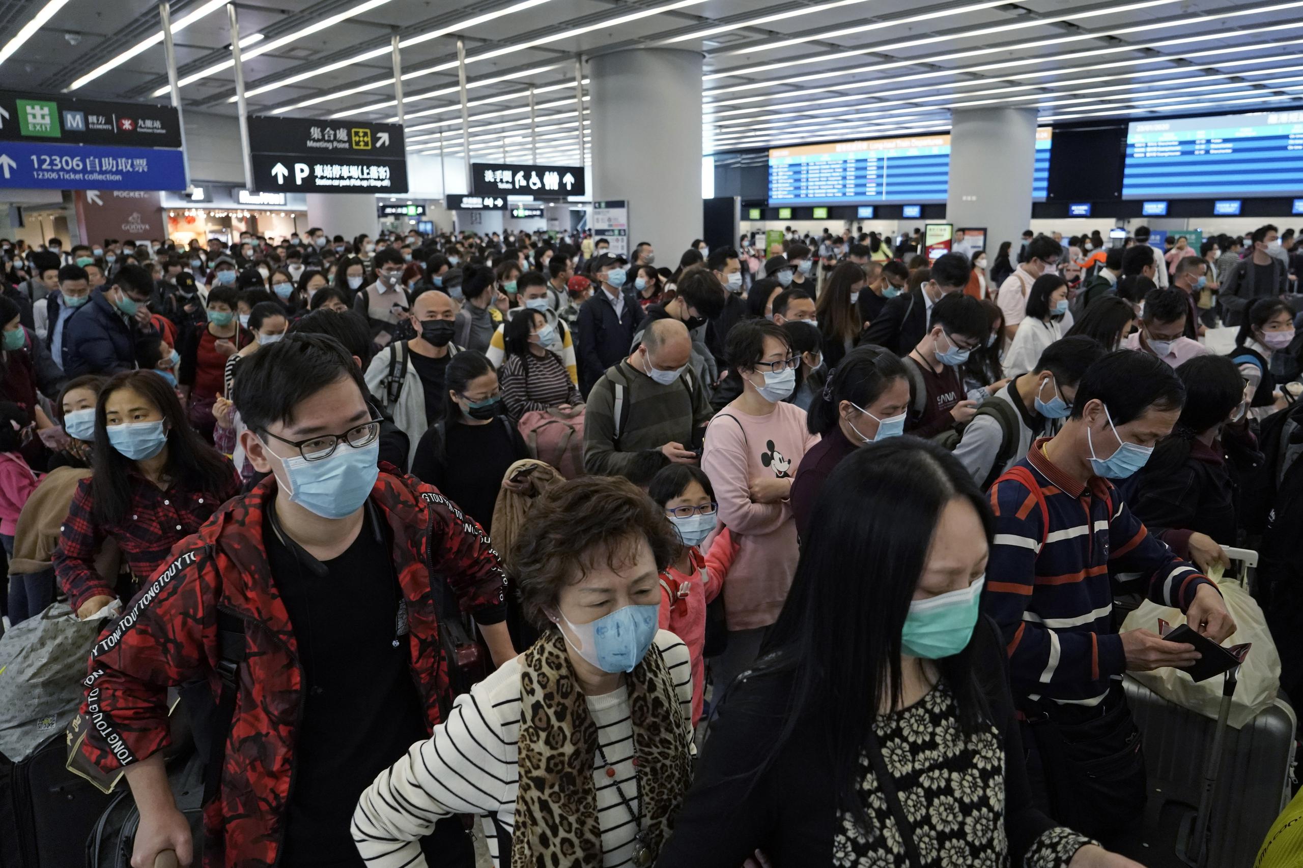 FILE - In this Thursday, Jan. 23, 2020 file photo, Passengers wear protective face masks at the departure hall of the high speed train station in Hong Kong.  Fear about the effects of a new virus found in China is spreading faster through financial markets around the world than the sickness itself. U.S. stocks fell to their biggest weekly loss since early October on worries that the new coronavirus could ultimately hurt travel and global economic growth. (AP Photo/Kin Cheung, File)