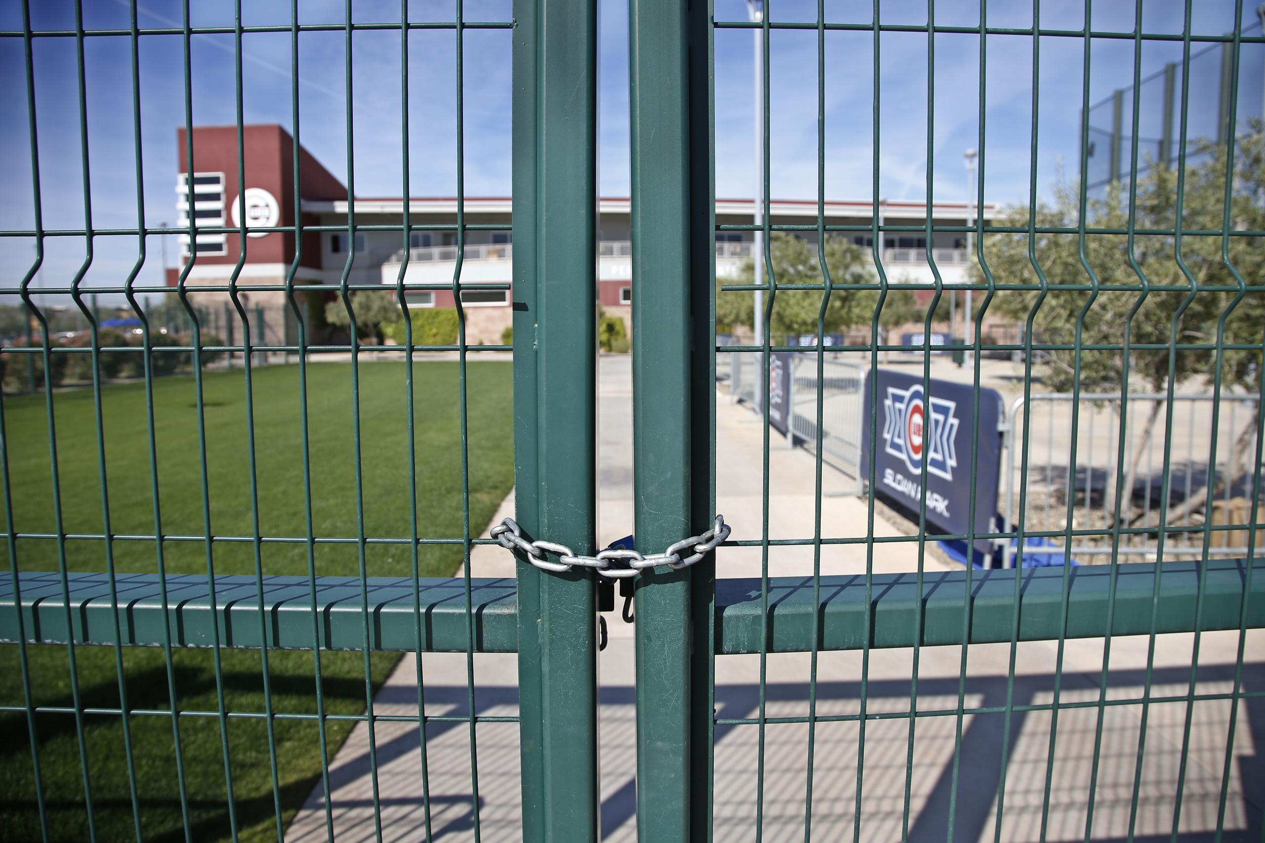 La foto del lunes 16 de marzo de 2020 muestra las rejas cerradas en el complejo de prácticas de los Cachorros de Chicago en Mesa, Arizona.