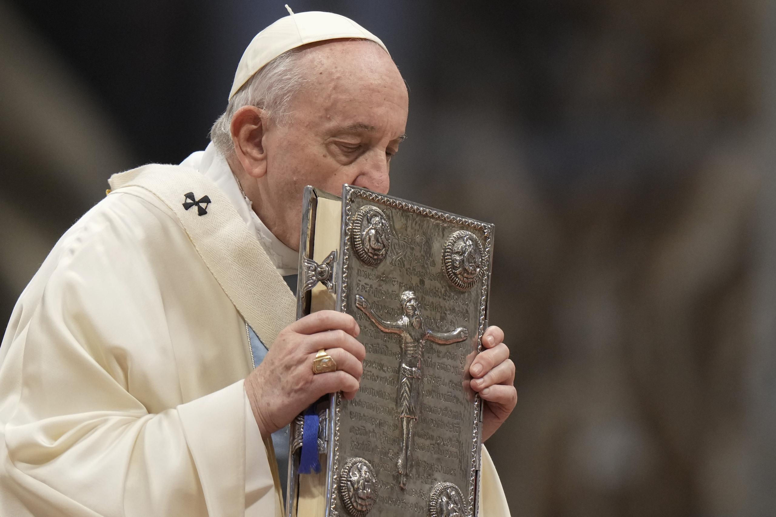 El papa Francisco besa el Libro Sagrado durante la misa de Año Nuevo, en la Basílica de San Pedro, en el Vaticano, el 1 de enero de 2022. (AP Foto/Andrew Medichini)