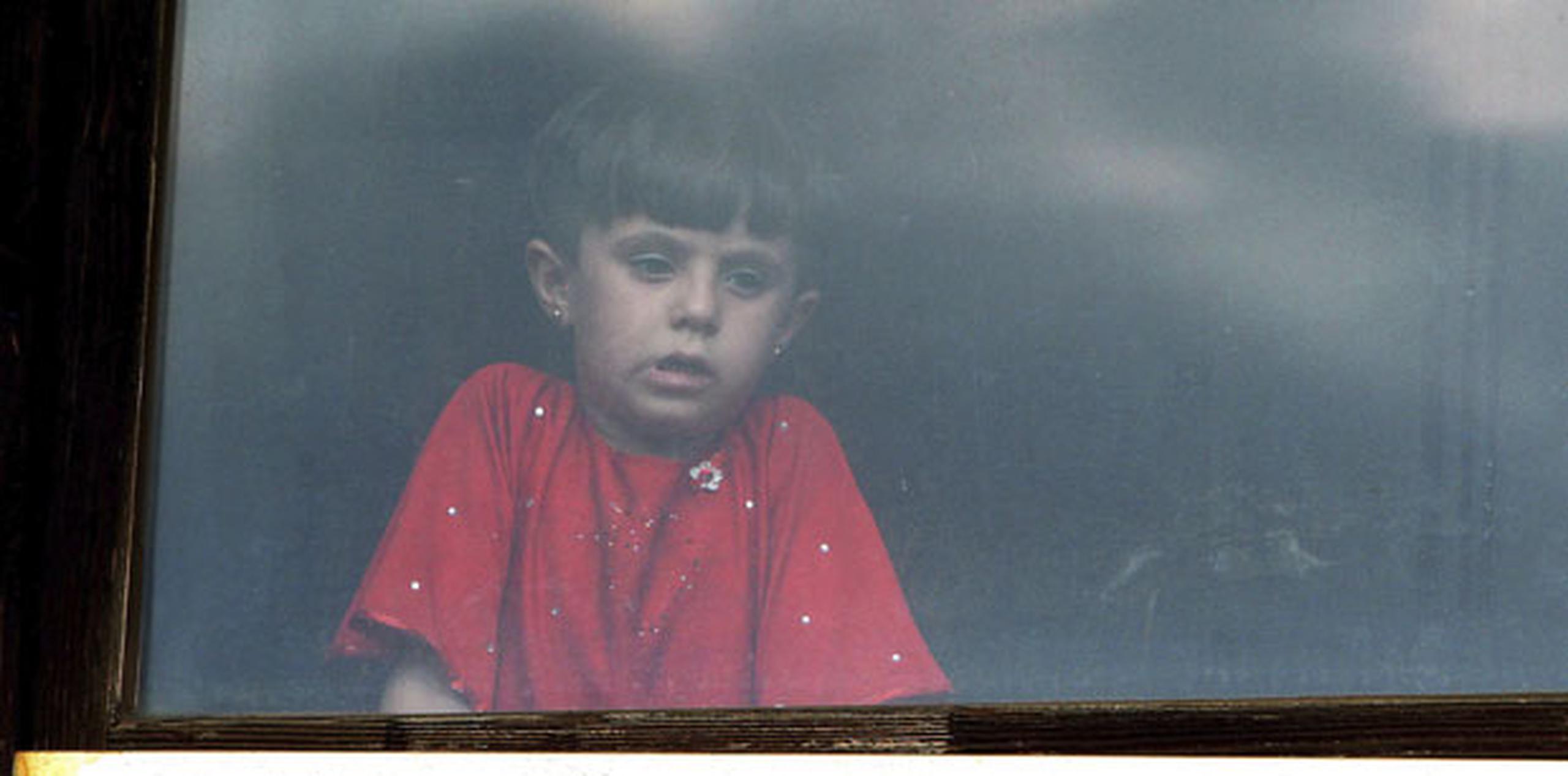 Una niña siria mira por la ventana de un centro de refugiados en Presevo, Serbia. (EFE/Djordje Savic)
