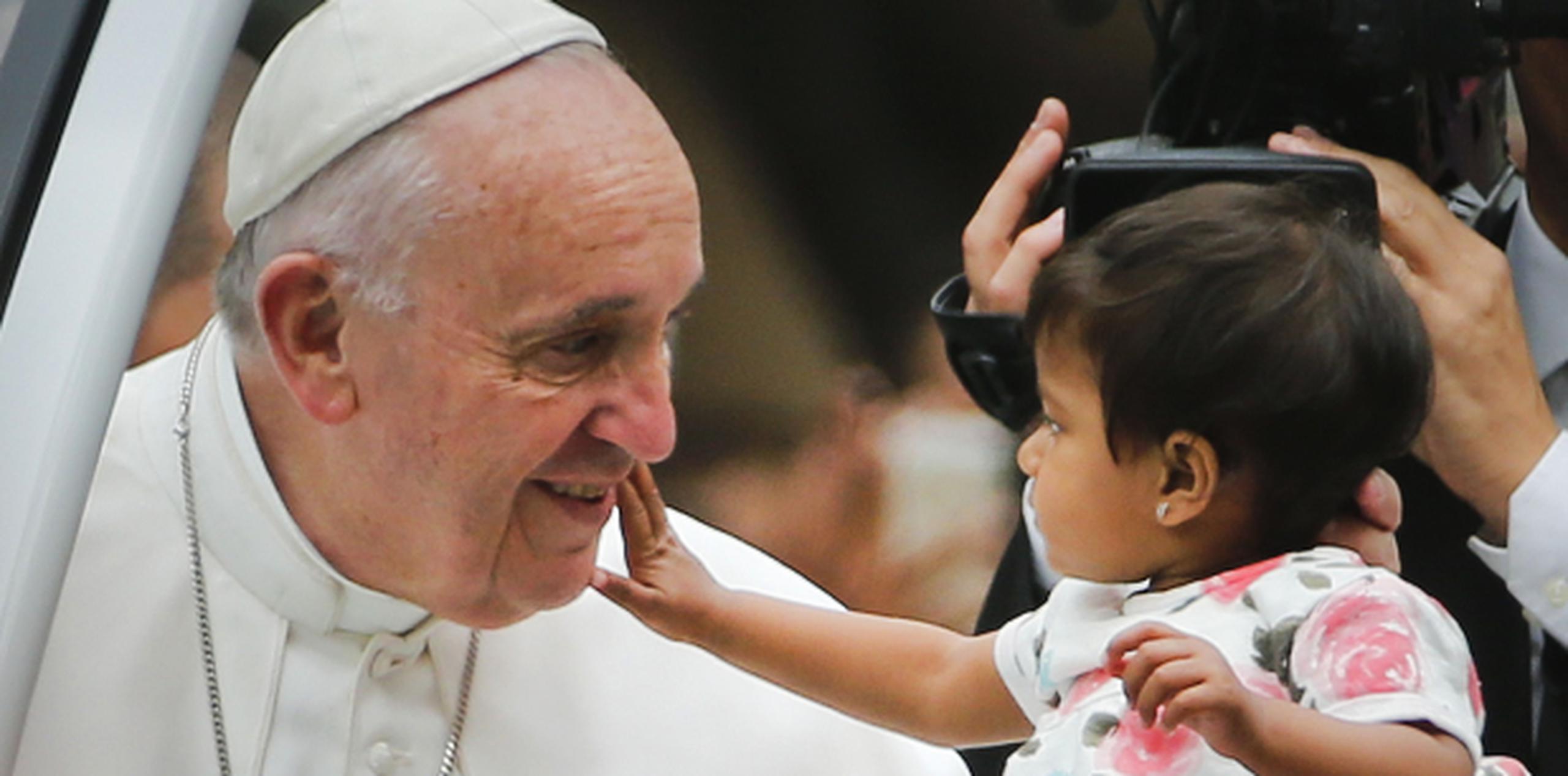 Una niña acaricia al papa durante su recorrido por Filadelfia, última parada en su gira por América, primero en Cuba y luego Estados Unidos. (AP)