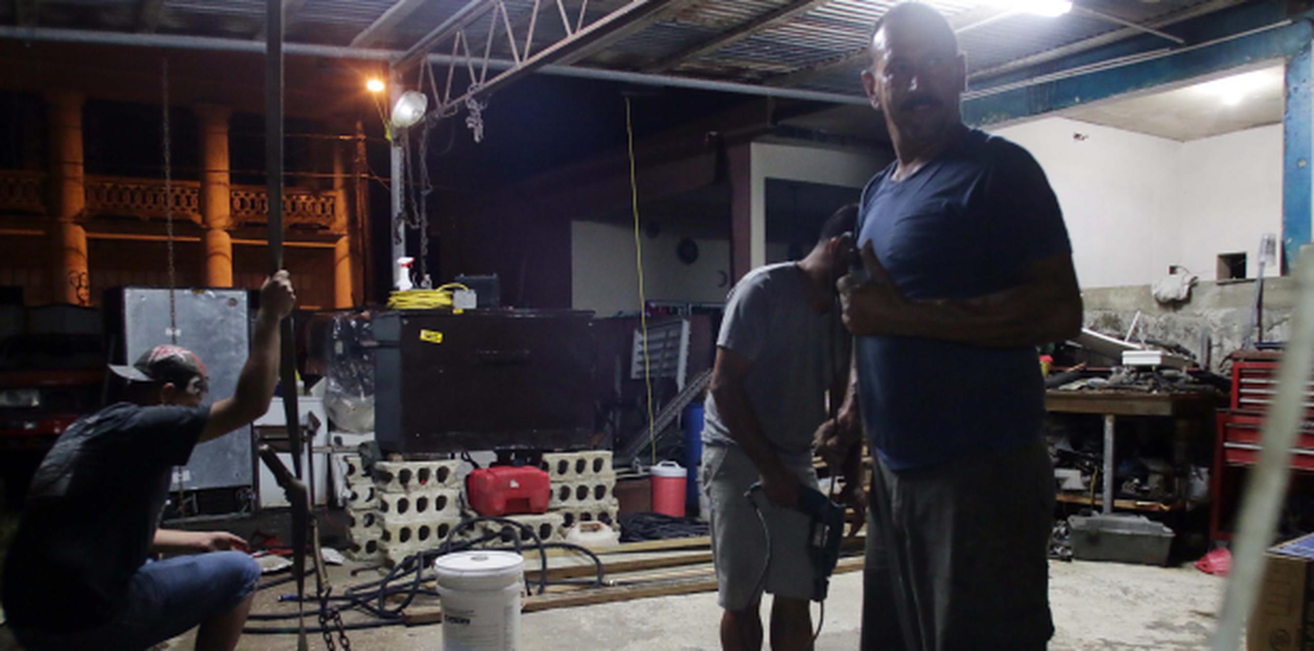 Frankie Diaz, de la comunidad la Puntilla en Arecibo, realizaba ayer los últimos preparativos de seguridad del taller de mecánica. (PARA GFR MEDIA/NELSON REYES FARIA)
