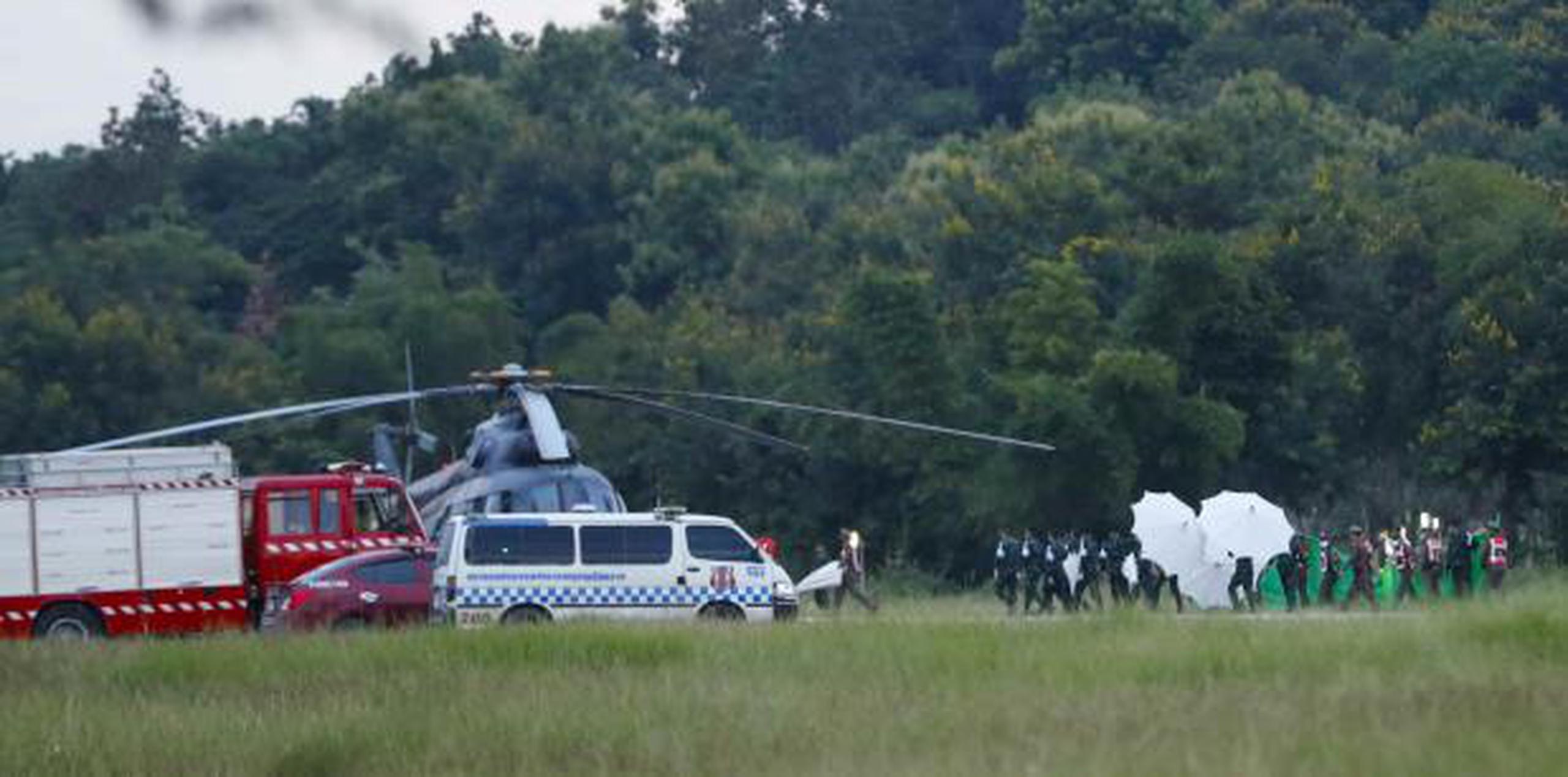Un equipo de emergencia corre hacia un helicóptero que se cree transporta a uno de los niños rescatados. (AP / Vincent Thian)