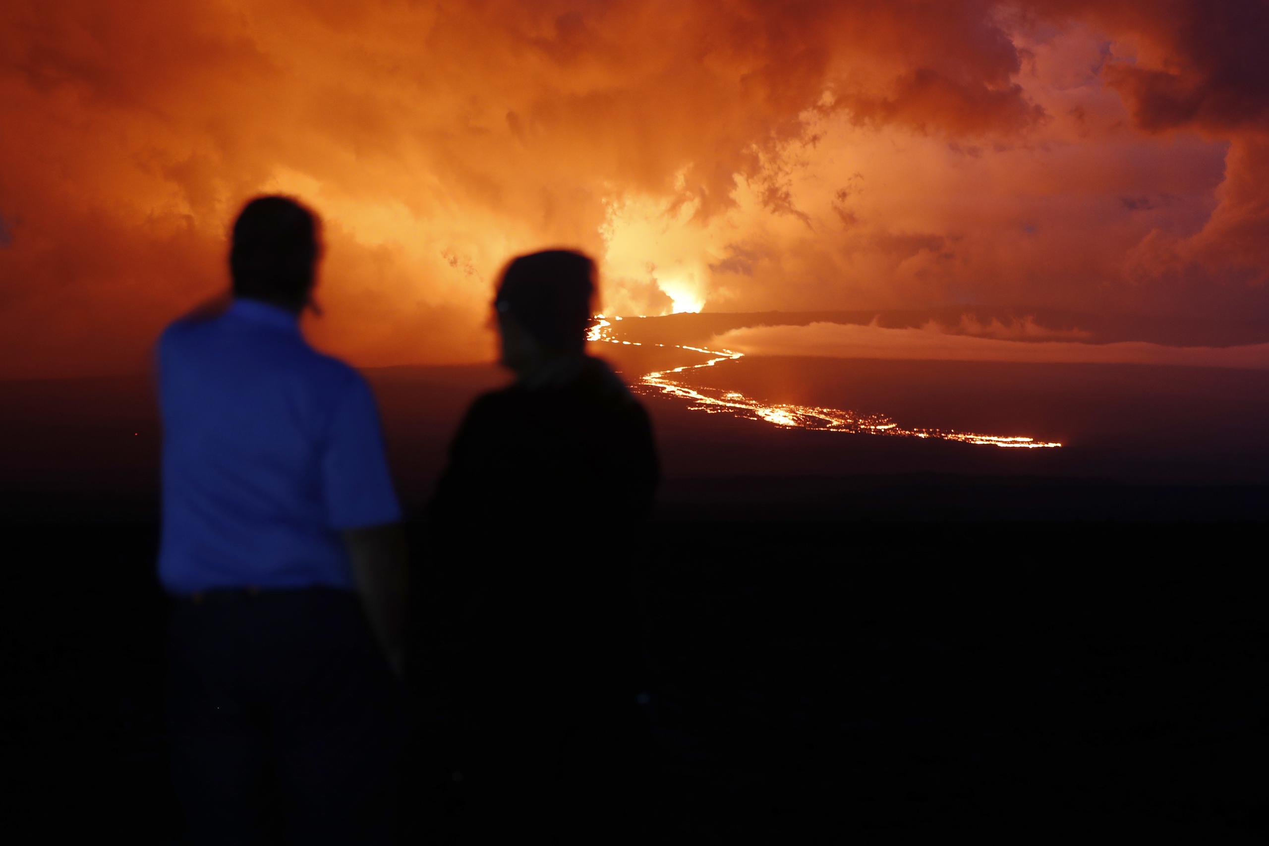 Espectadores contemplan el flujo de lava en la erupción dek volcán Mauna Loa, cerca de Hilo, Hawai.