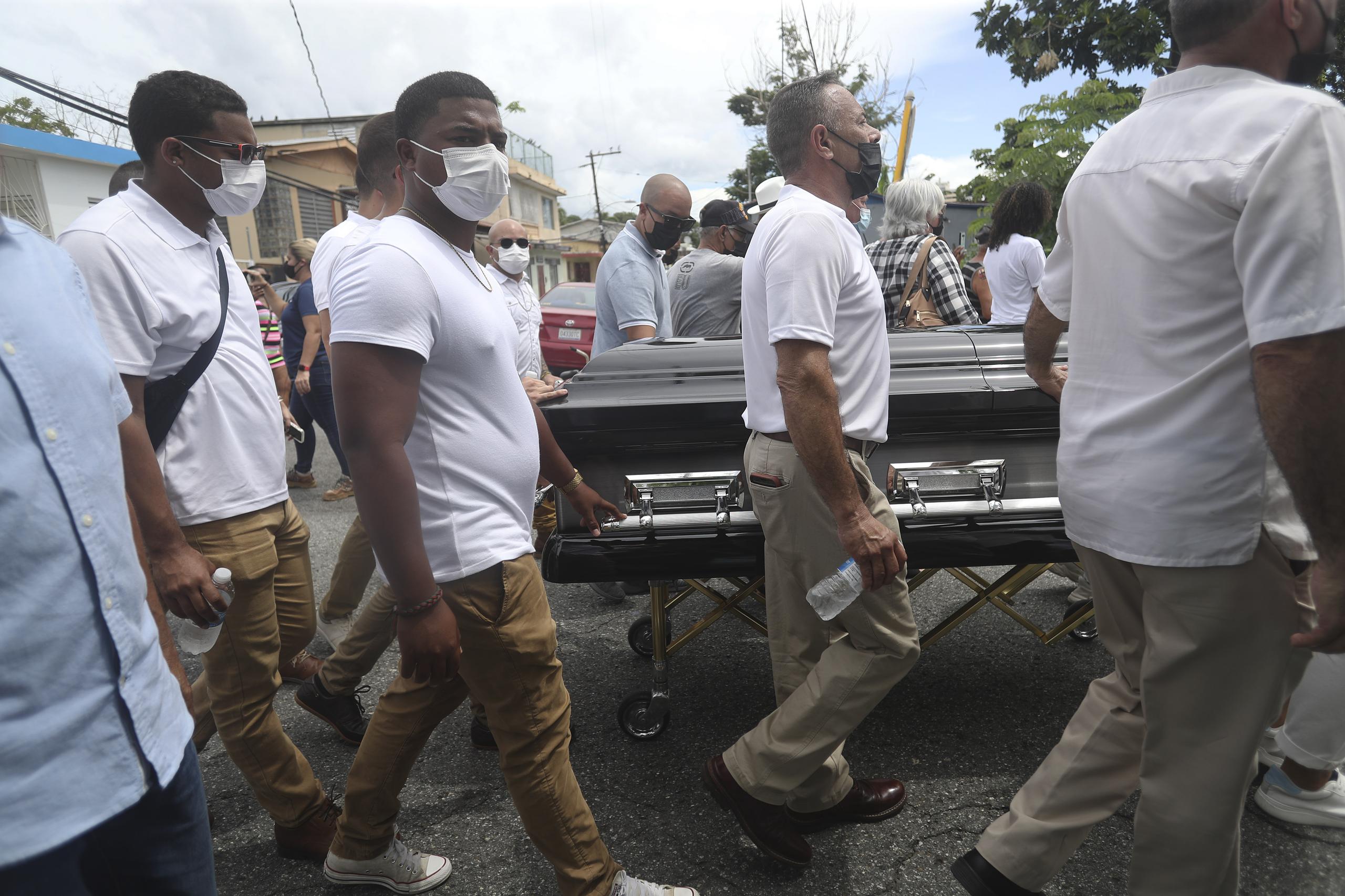 Familiares, amigos y fanáticos participan de los actos fúnebres de Roberto Roena en Mayagüez, cuyos restos llegaron al barrio Dulces Labios a media mañana. 