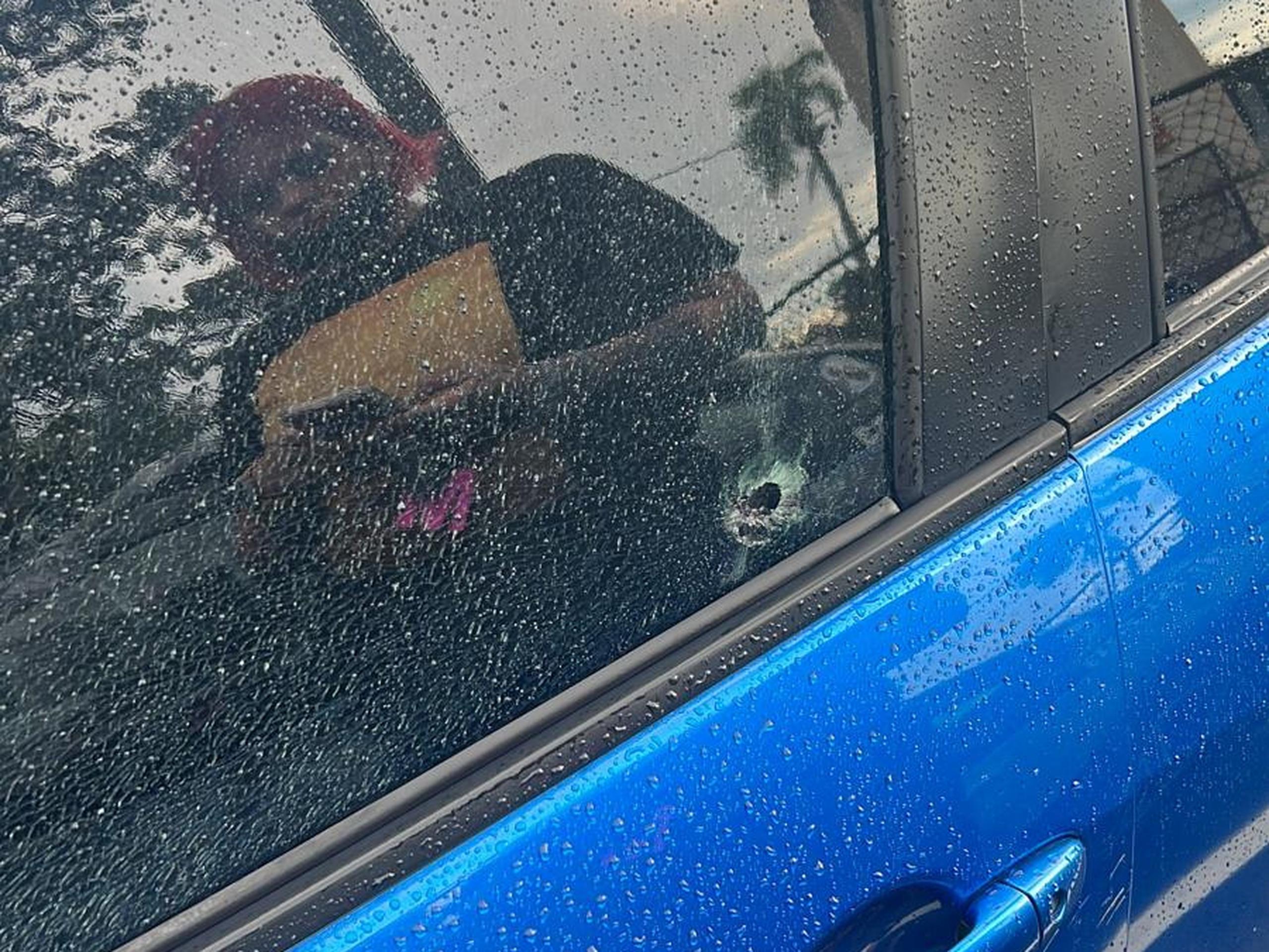 Fotos del Toyota Yaris azul con un impacto de proyectil de bala en el cristal de la puerta del conductor.