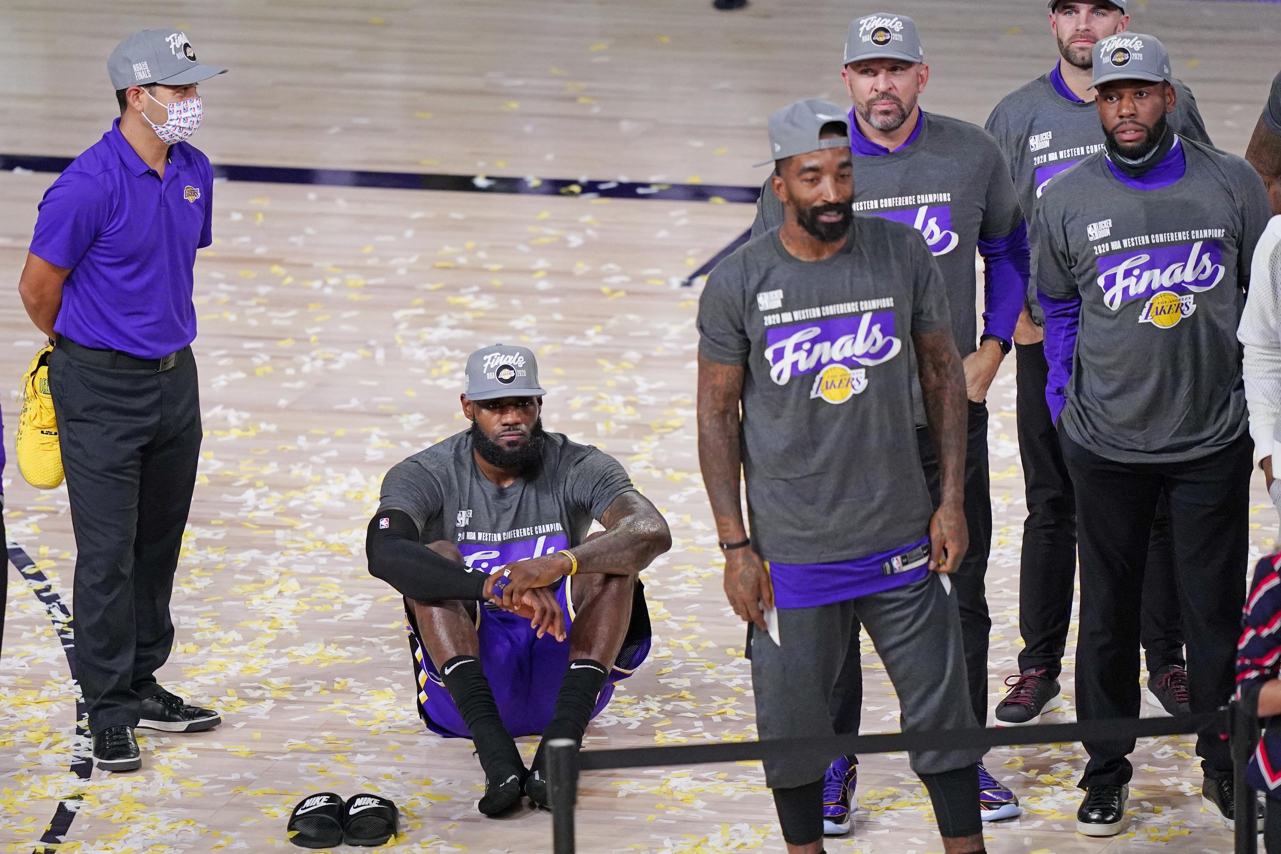 LeBron James espera sentando en el tabloncillo el trofeo de campeón de la Conferencia del Oeste ganado por los Lakers.