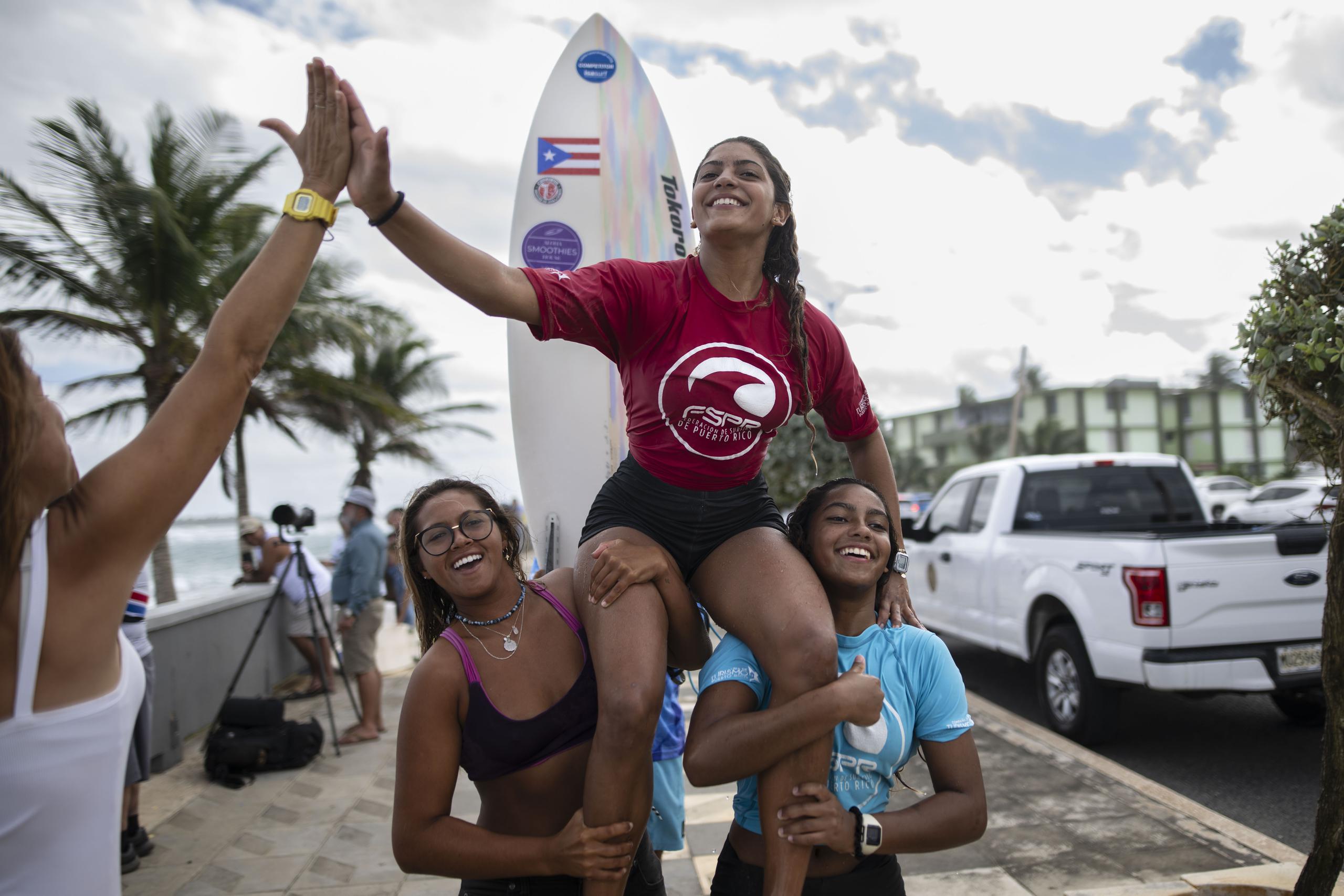Miamar sale del agua cargada por su hermana Sinaí (a la derecha) y otra amiga luego de ganar la categoría de 18 años y menos de la cuarta parada del Circuito Nacional de Surfing.