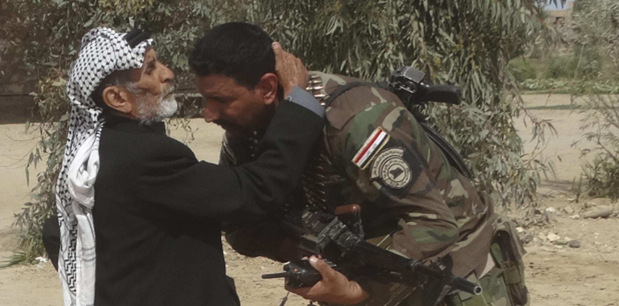 Un hombre besa a un soldado iraquí luego que lograrán la retirada de militantes de Estado Islámico de su pueblo, Ramadi. (EFE)