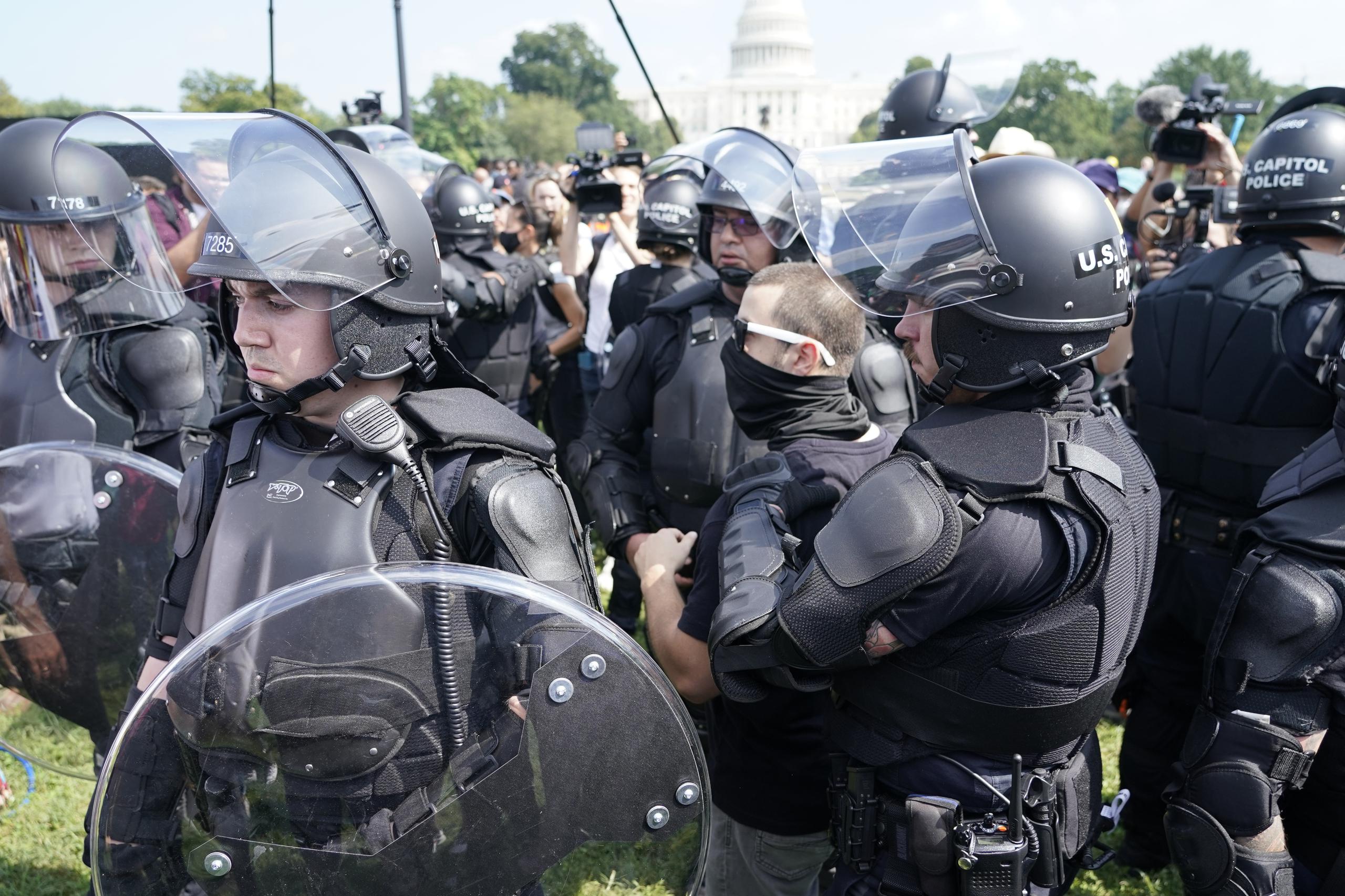 Varios policías rodean a un hombre (al centro, con anteojos) durante un mitin cerca del Capitolio de Estados Unidos en Washington, D.C.