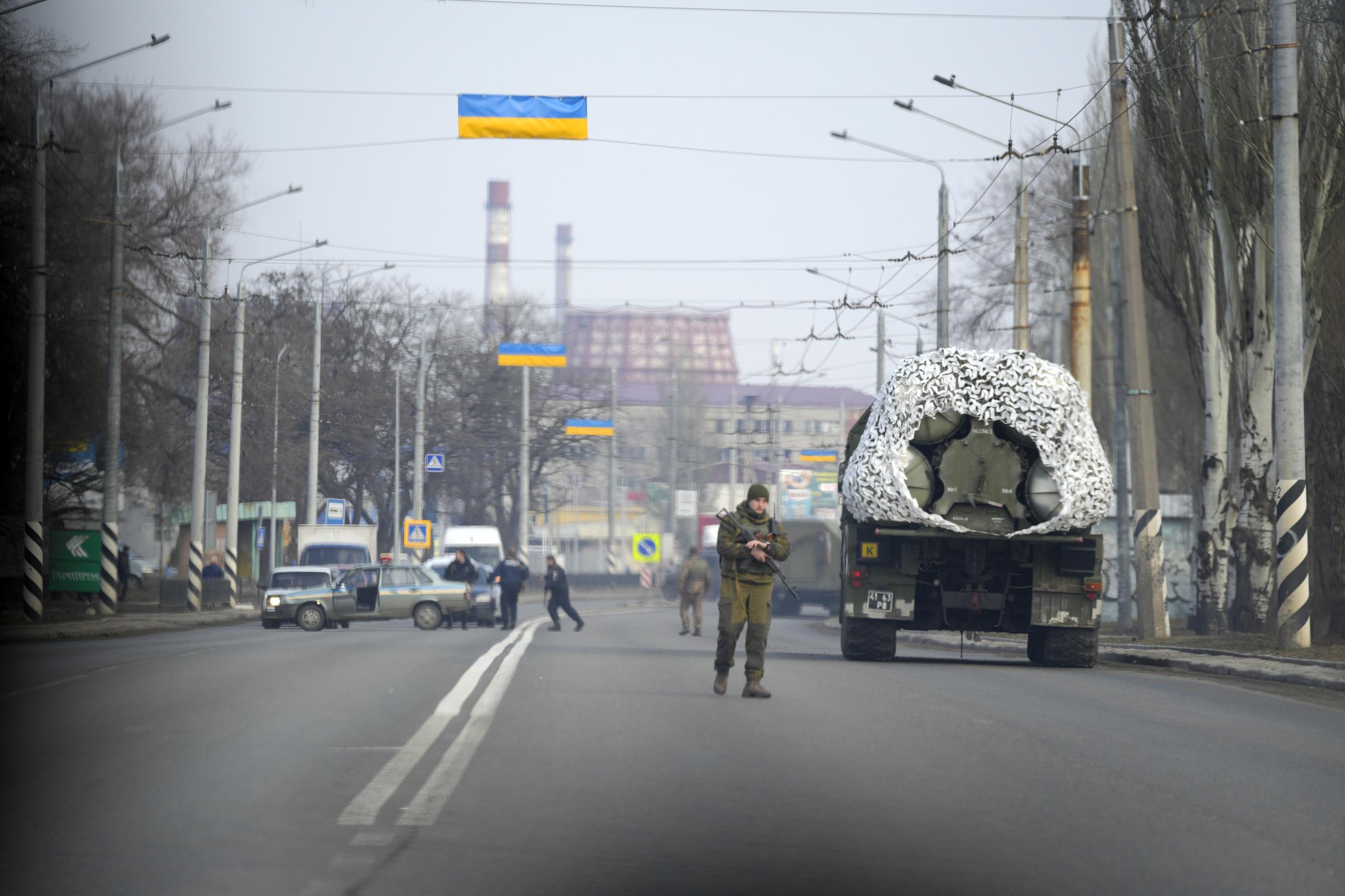 Un soldado ucraniano está junto a un vehículo militar en un camino en Kramatosrk, este de Ucrania, jueves 24 de febrero de 2022.