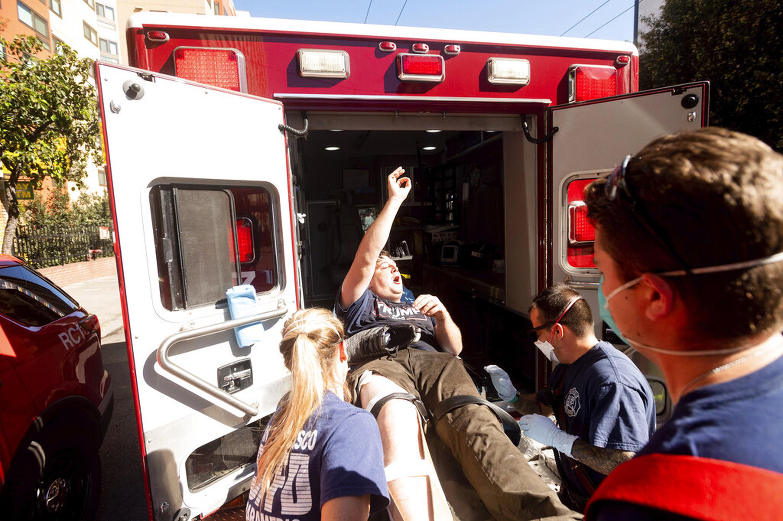 Un partidario del presidente Donald Trump que participaba en una manifestación con un reducido número de personas es subido a una ambulancia por paramédicos después de que contramanifestantes los agredieran en San Francisco.