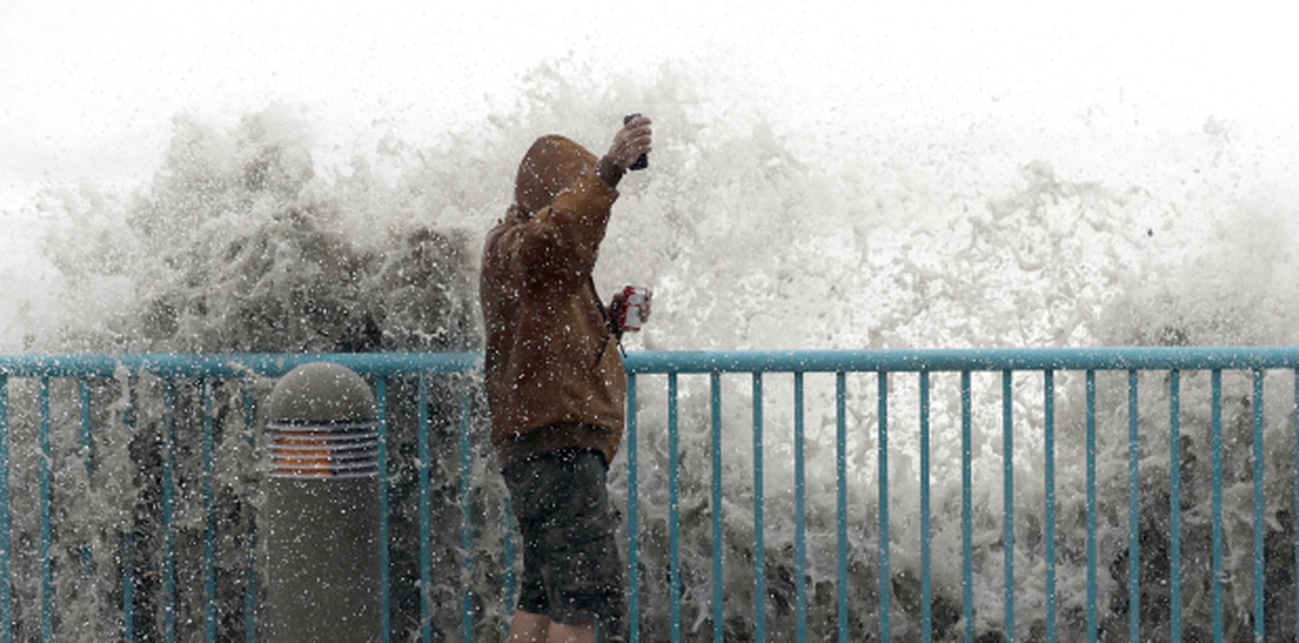 Brian Johns reta las olas en Daytona Beach para tomar un vídeo. (Prensa Asociada)