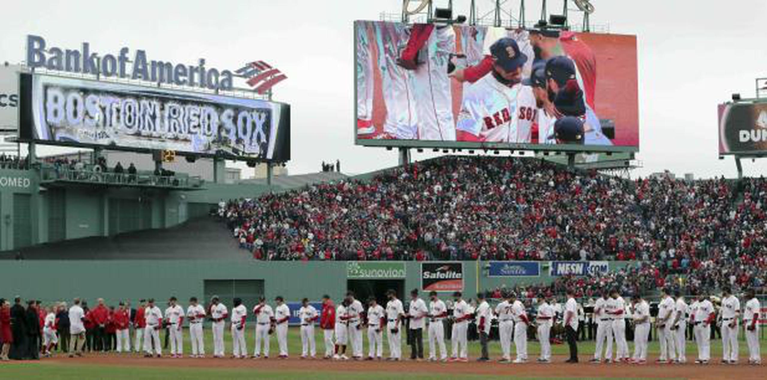 Mookie Betts, de los Red Sox, aparece en la pantalla mientras se une a sus compañeros durante la ceremonia para recibir sus anillos de campeones. (AP / Charles Krupa)