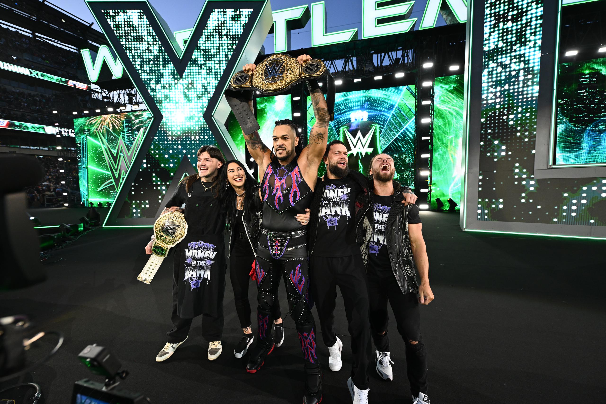 Damian Priest holds the WWE Heavyweight Championship with his teammates. "Doomsday".  From left to right: Dominik Mysterio, Rhea Ripley, Finn Balor and JD McDonagh.