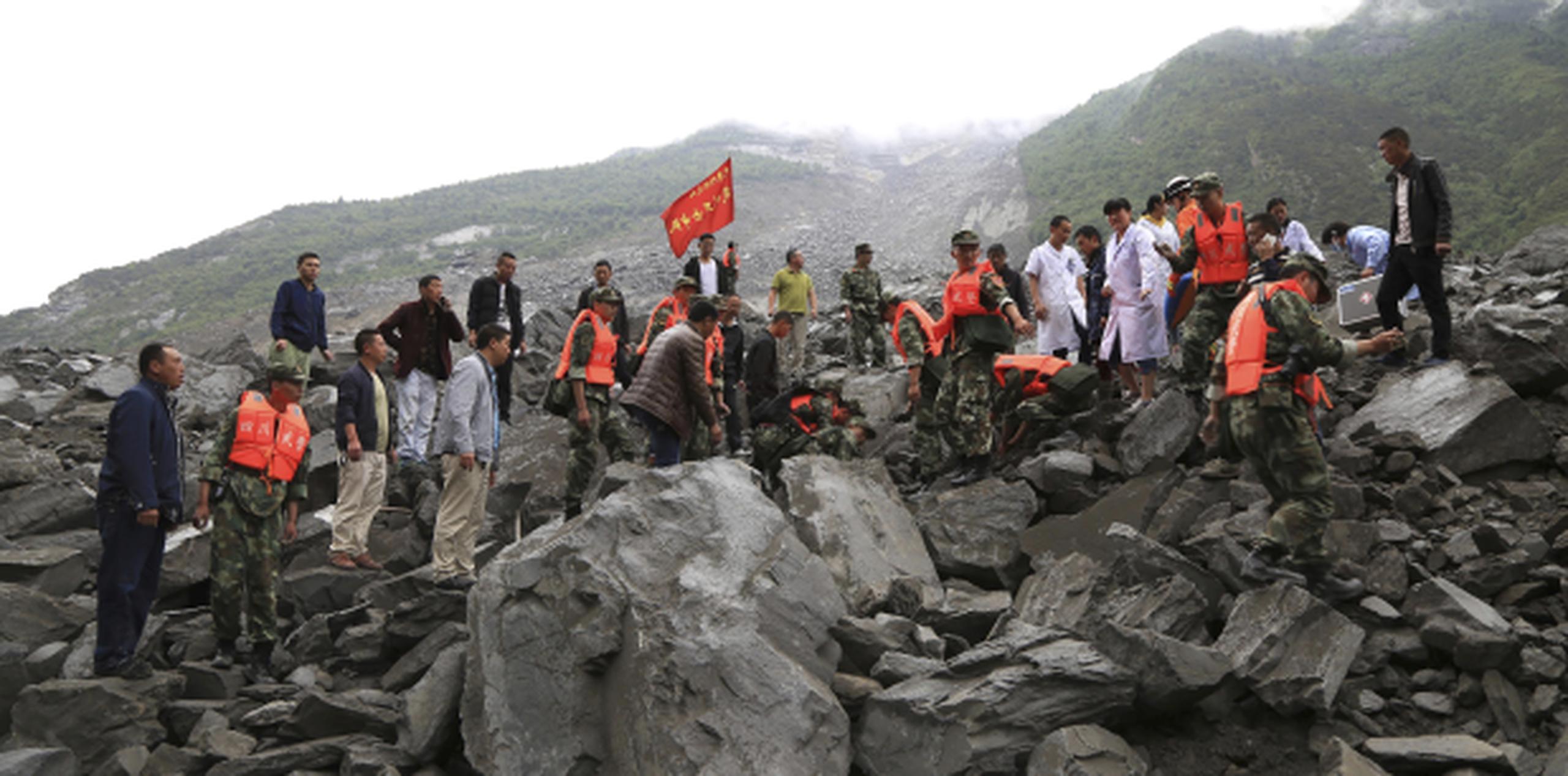 Rescatistas y personal de emergencias intentan encontrar sobrevivientes bajo las piedras que dejó el deslave en Xinmo, provincia de Sichuan. (He Qinghai/Xinhua via AP)