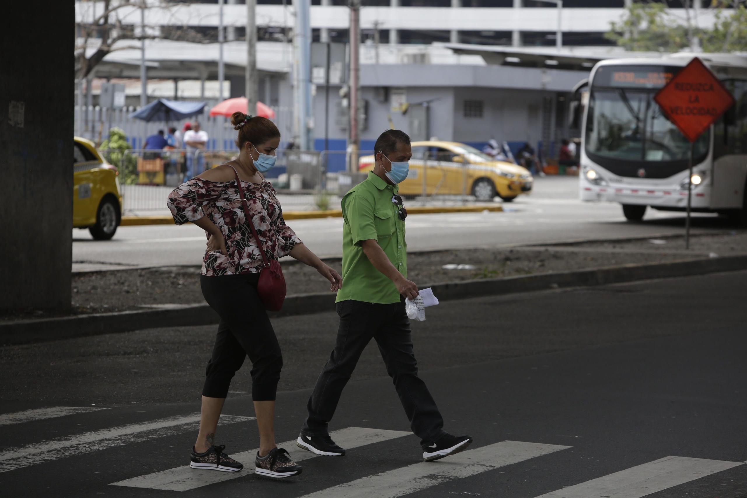 Dos personas caminan protegidos con tapabocas en Ciudad de Panamá .