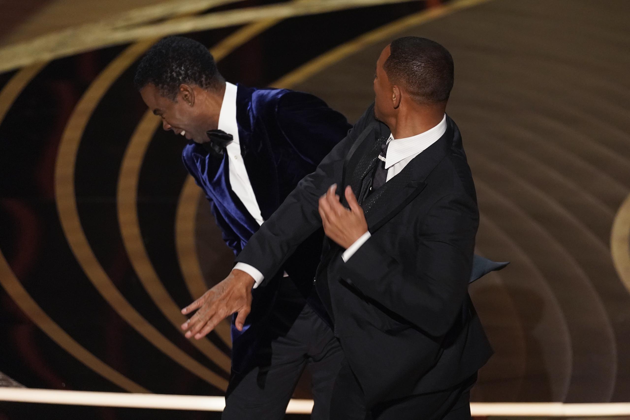 Will Smith, a la derecha, le pega al presentador Chris Rock en medio de la transmisión de los premios Oscar.